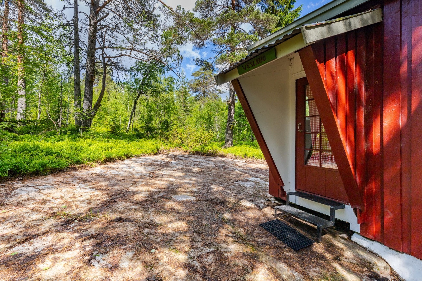Hytta har et overbygd inngangsparti med glassdør inn til entré. Galleribilde