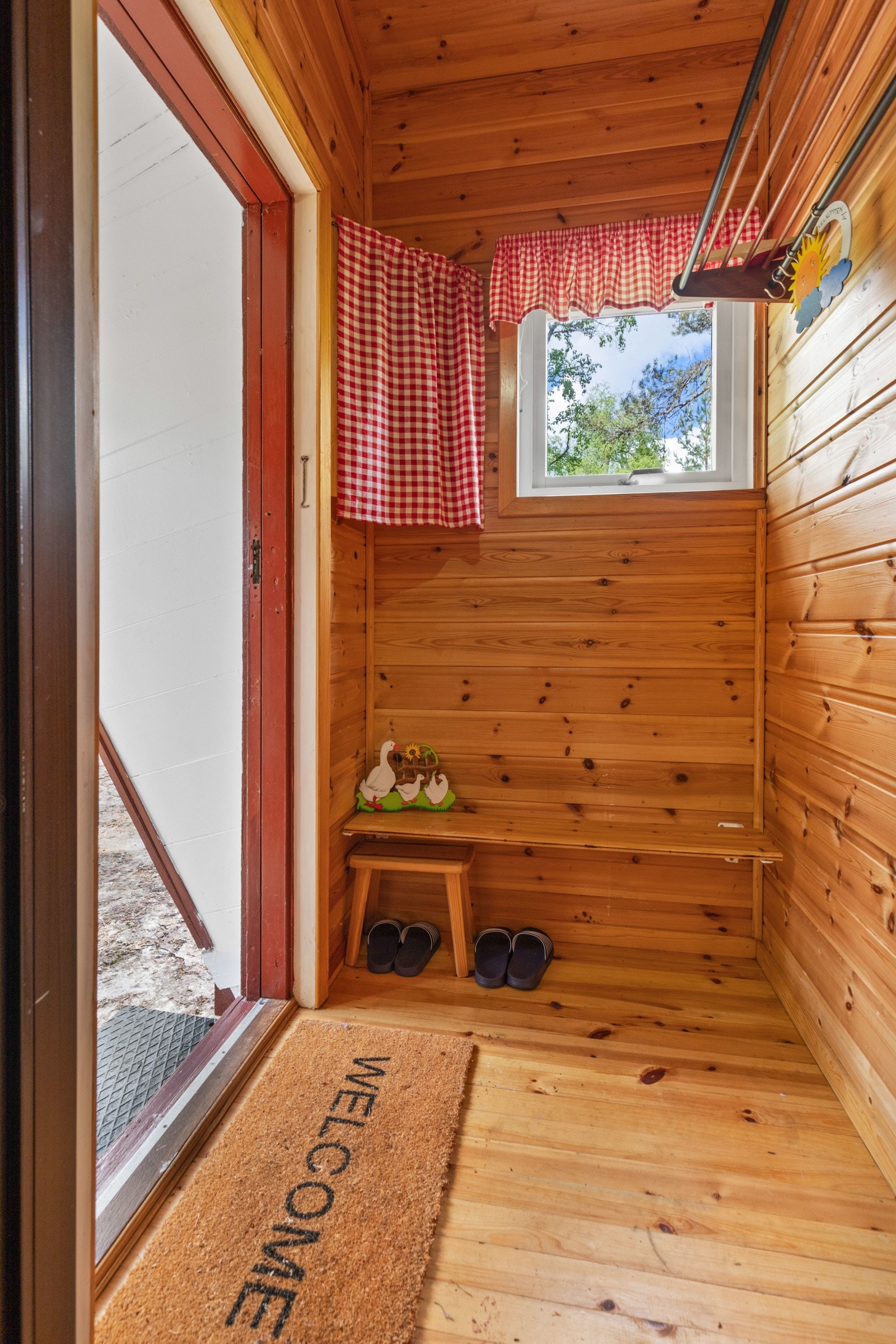 Entreen får dagslys fra et vindu, og på veggen er det montert garderobe til yttertøy og sko. Galleribilde