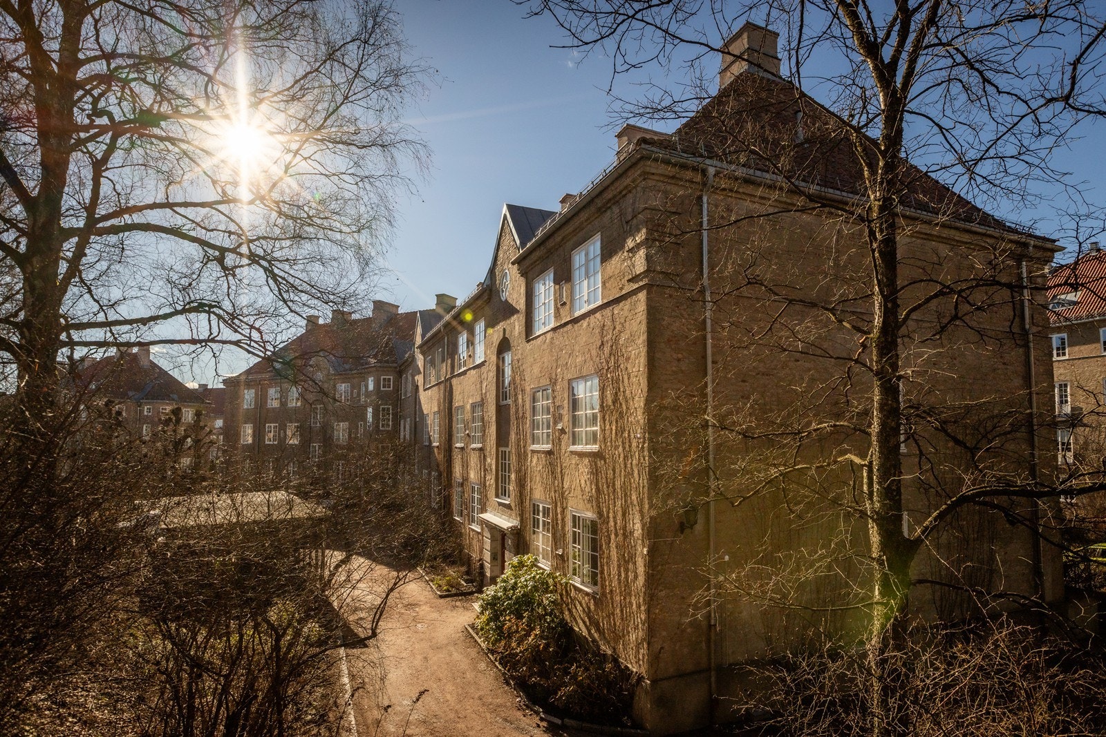 Fasade. Bakgården består av et rikt utvalg av stauder og blomster, jordbærplanter, rabarbra, ulike bærbusker samt kirsebær og epletrær Galleribilde