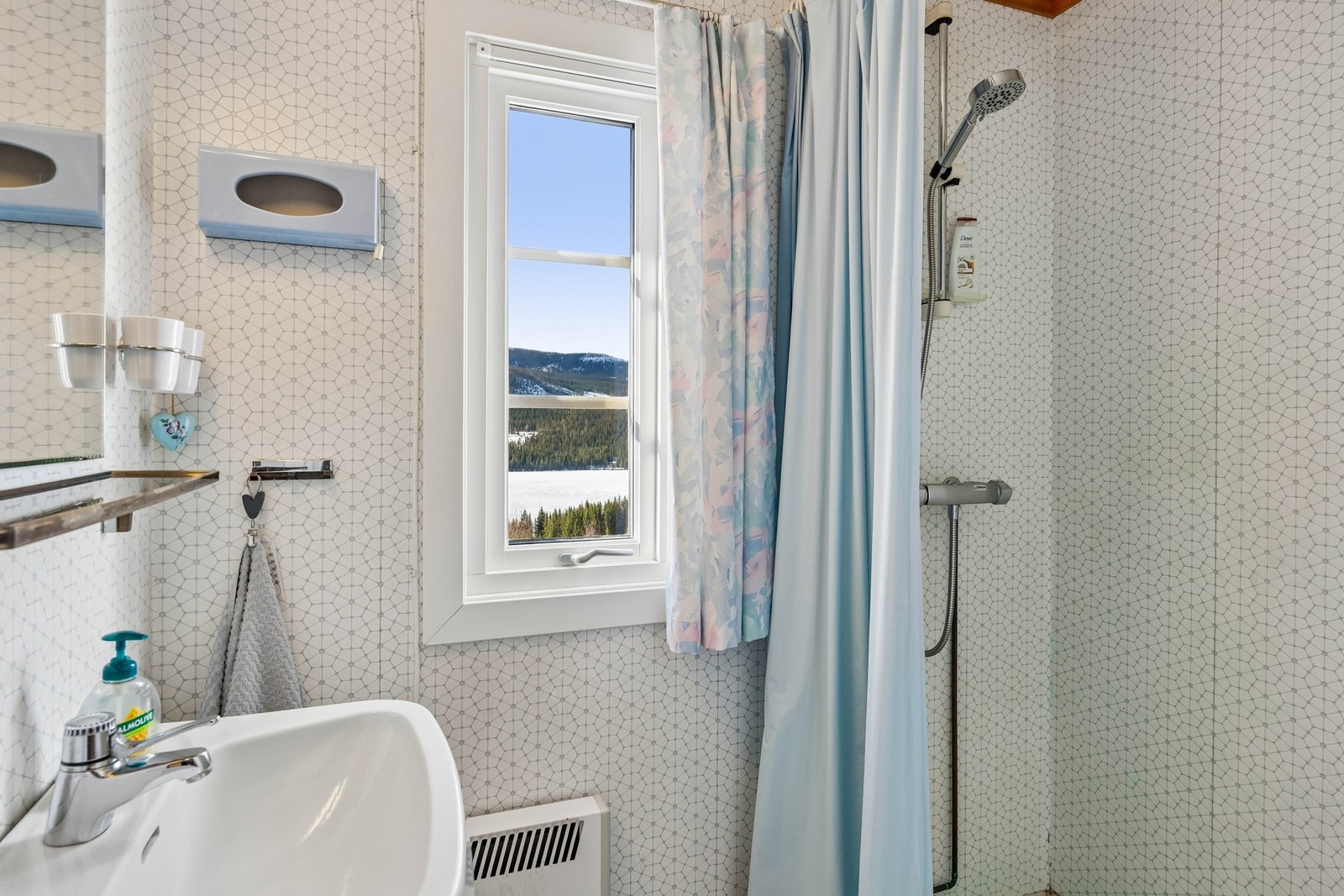 Badet er fra byggeår, og har gulvbelegg på gulv og våtromstapet på veggene. Montert dusj på vegg med forheng, samt servant. Galleribilde
