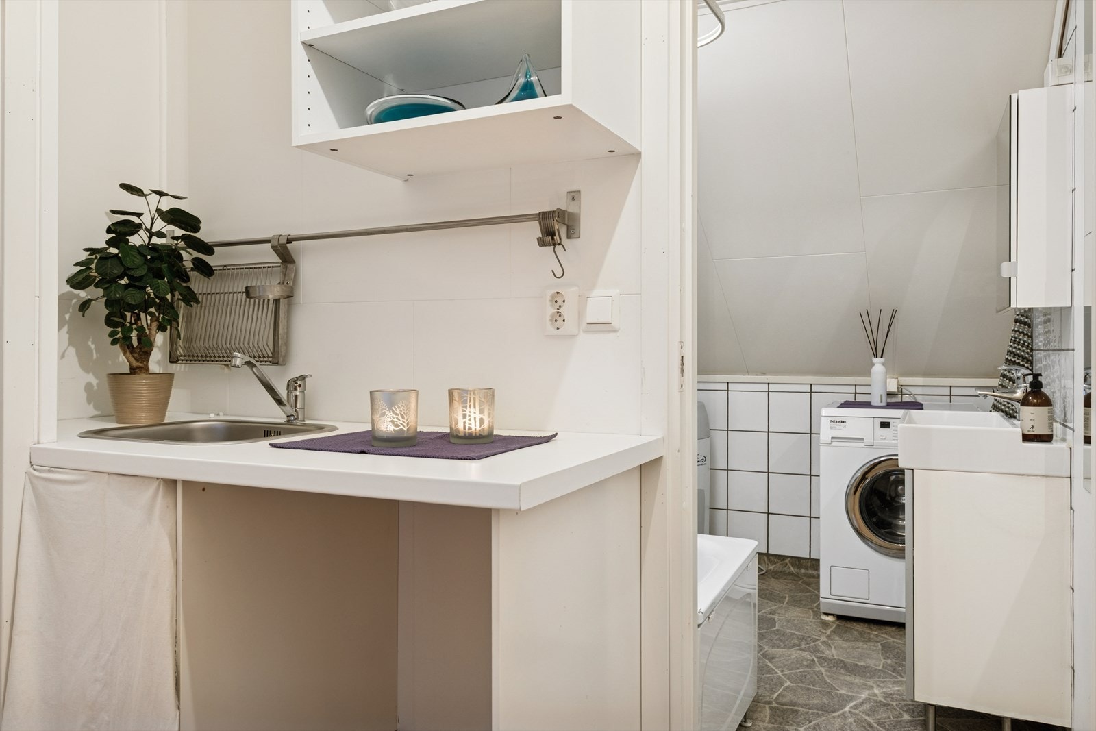 Loftetasjen har tidligere vært utleid og har derfor etablert et kjøkken. Videre kommer man til et praktisk baderom/vaskerom. Galleribilde