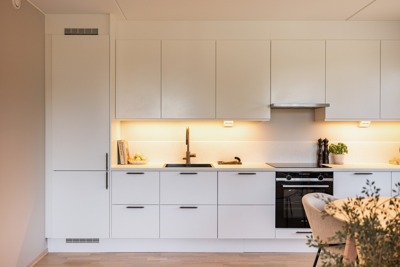 Hvitevarene fra Siemens er integrert og inkluderer induksjonstopp, stekeovn, kjøl-/fryseskap og oppvaskmaskin. Ventilator fra Røroshetta er integrert i overskap over platetopp, med avtrekk tilkoblet boligens balanserte ventilasjonsanlegg. Galleribilde