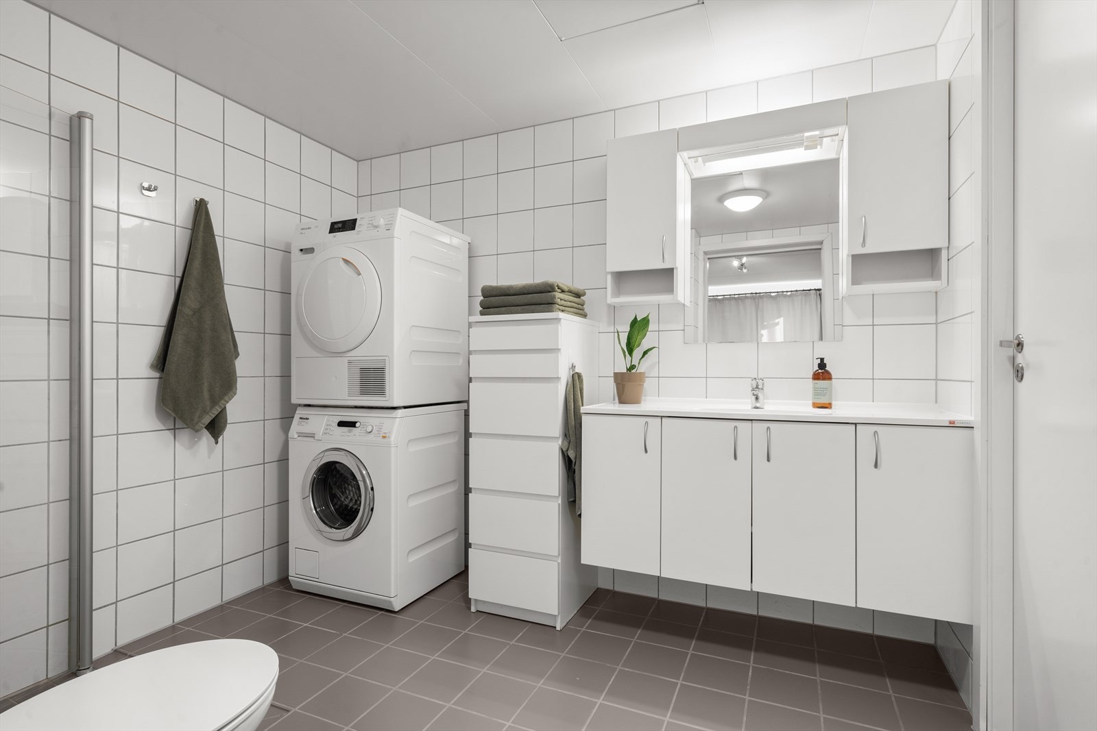 Pent flislagt bad med vannbåren gulvvarme. Opplegg for vaskemaskin og tørketrommel. Galleribilde