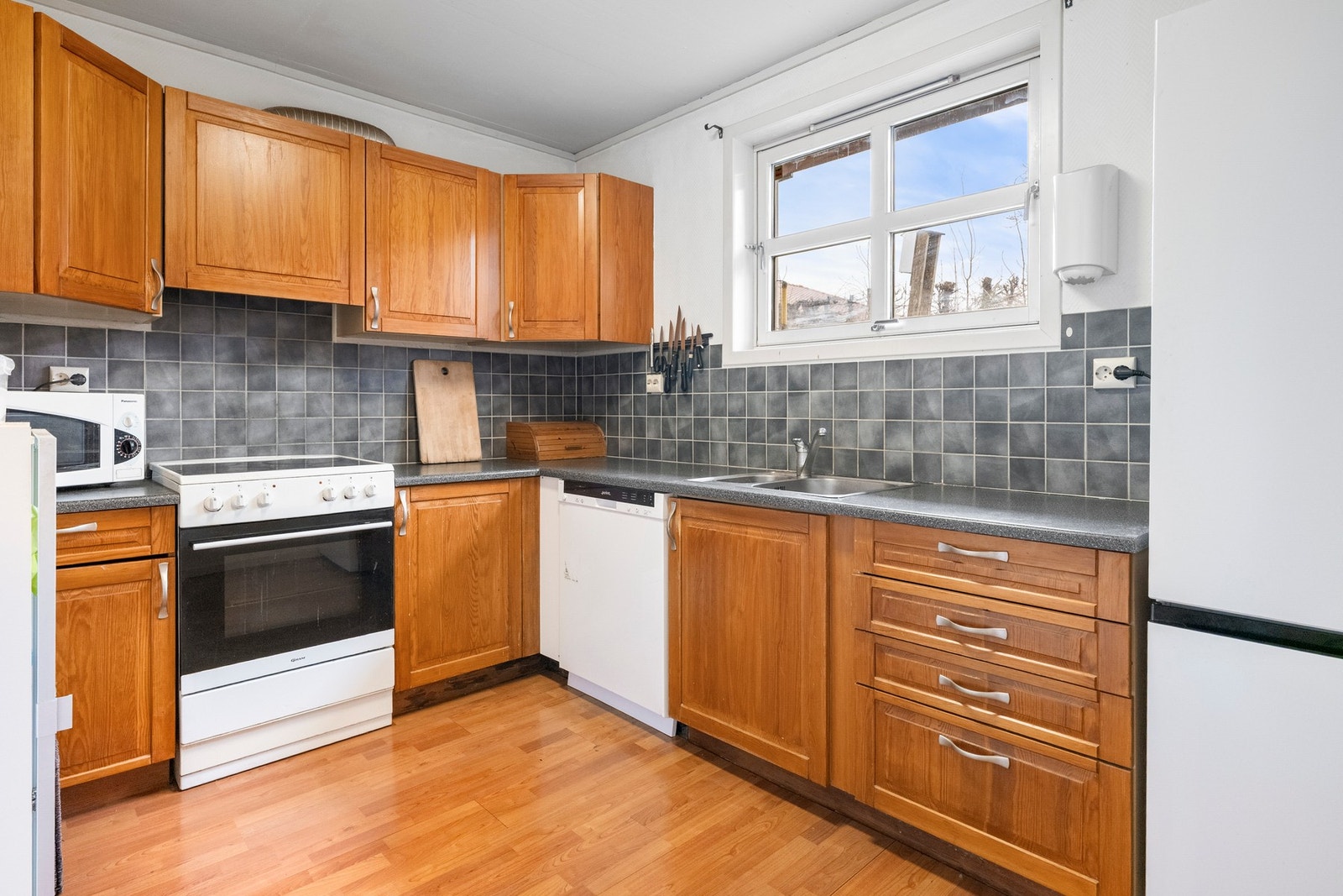 Kjøkken med profilerte fronter og benkeplate i mørk laminat. Galleribilde