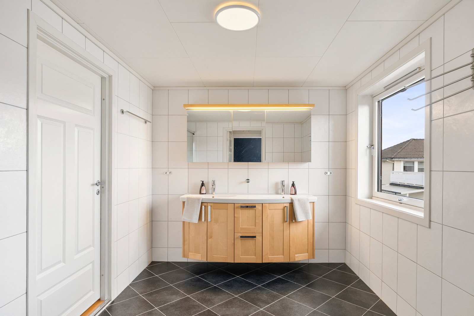 I 2. etasje finner du to flislagte bad med lyse fliser på veggene kombinert med mørkere fliser på gulvet. Galleribilde