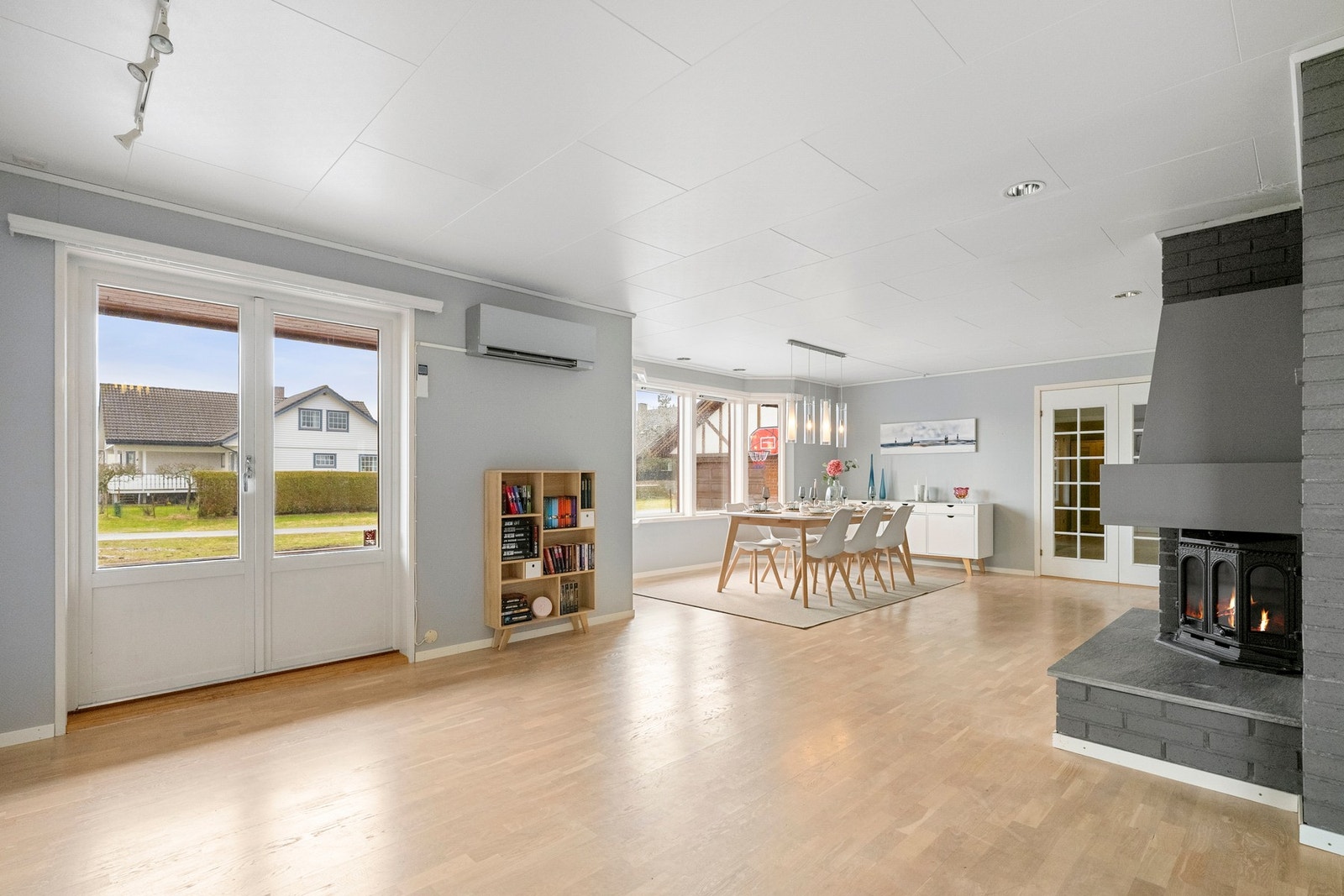 Midt i rommet står en peis som bidrar til lun varme og en hyggelig atmosfære på kjølige kvelder, mens varmepumpen sørger for et godt inneklima gjennom hele året. Galleribilde