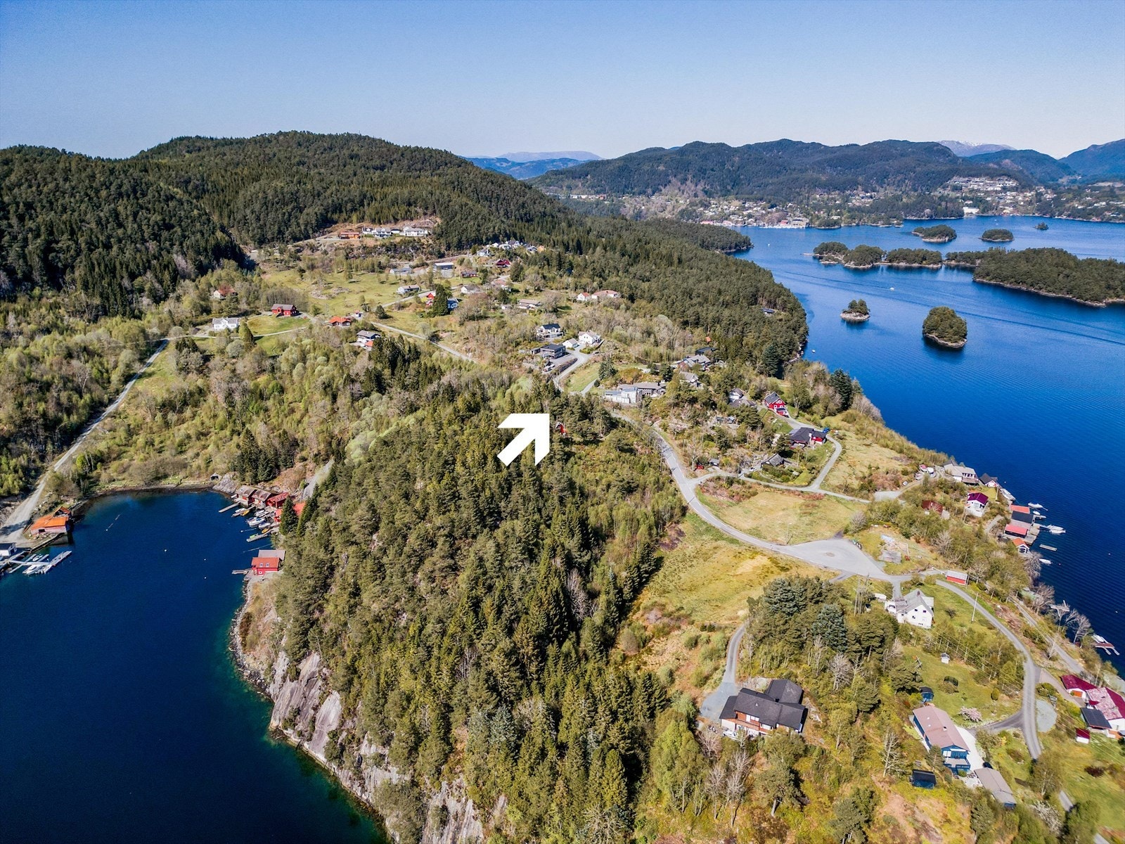 Tomten ligger fint plassert på en høyde. I bakgrunnen ser vi innover til Askvik og Hagavik. Galleribilde