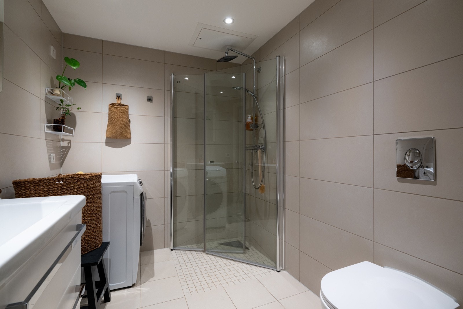 Baderommet er innredet med vegghengt servantinnredning med skuffer, speil, dusjhjørne og vegghengt toalett, samt opplegg for vaskemaskin. Galleribilde