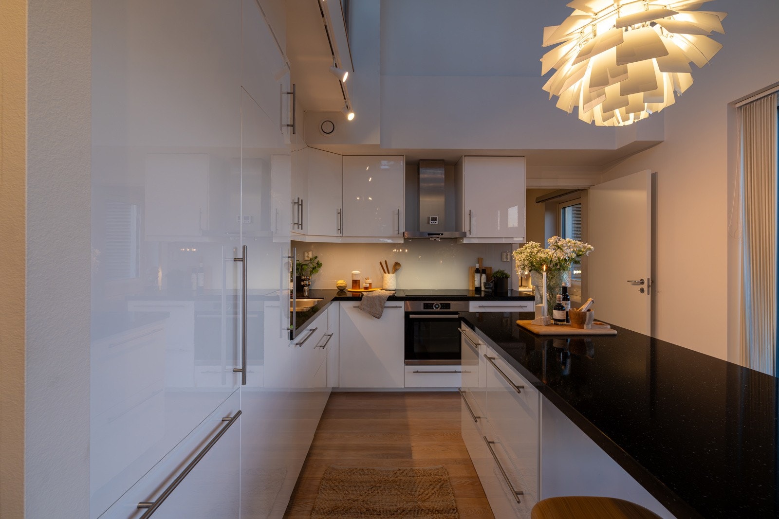 Innredningen har slette høyglans fronter, påkostede benkeplater i stein, underlimt oppvaskkum, glassplate mellom benk og overskap, benkeskapsbelysning og praktiske stikkontakter. Galleribilde