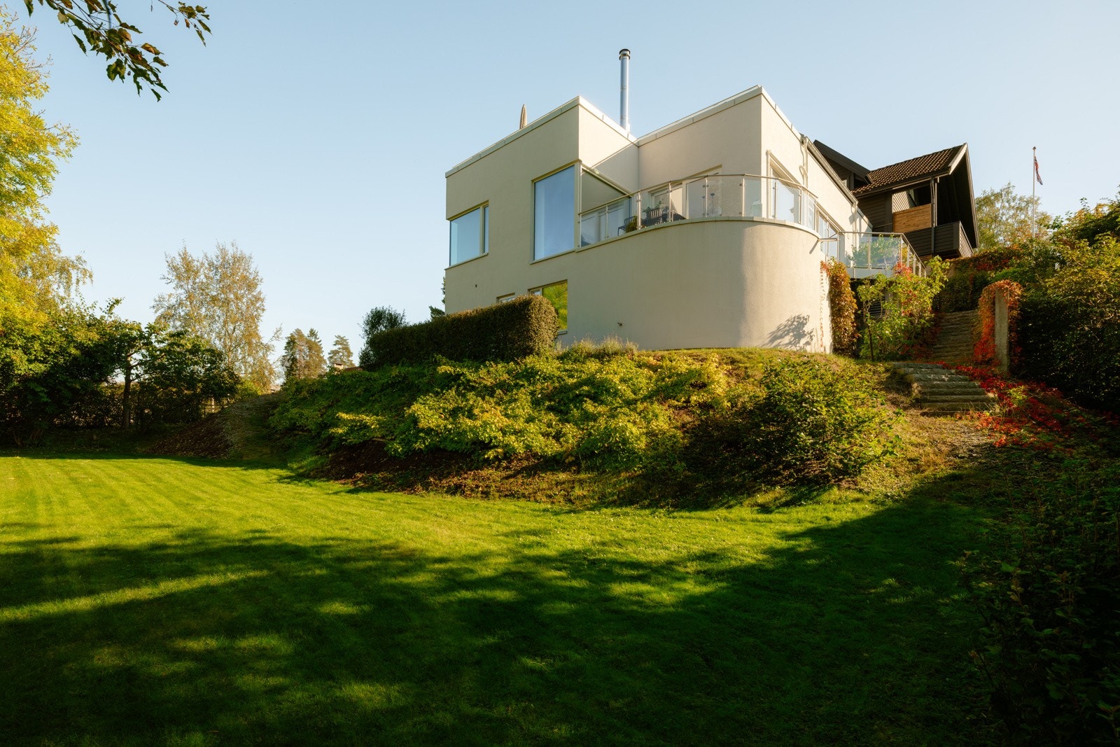 Her er det rikelig med plass til flere soner, enten det er koselige sittegrupper, et spiseområde, grillhjørne, eller blomsterkasser som gir liv og farge. Galleribilde