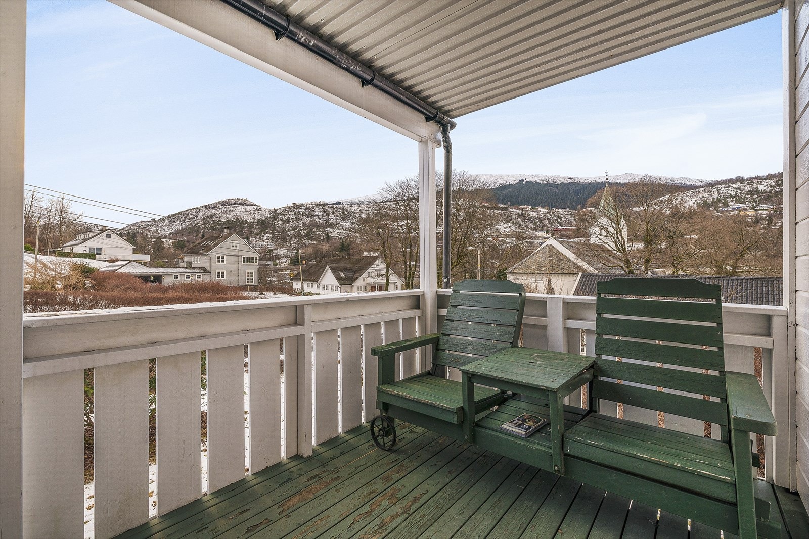 På verandaen skuer man over det hyggelig nærområdet, og kan sitte tørt selv de dagene det "drypper" litt! Galleribilde