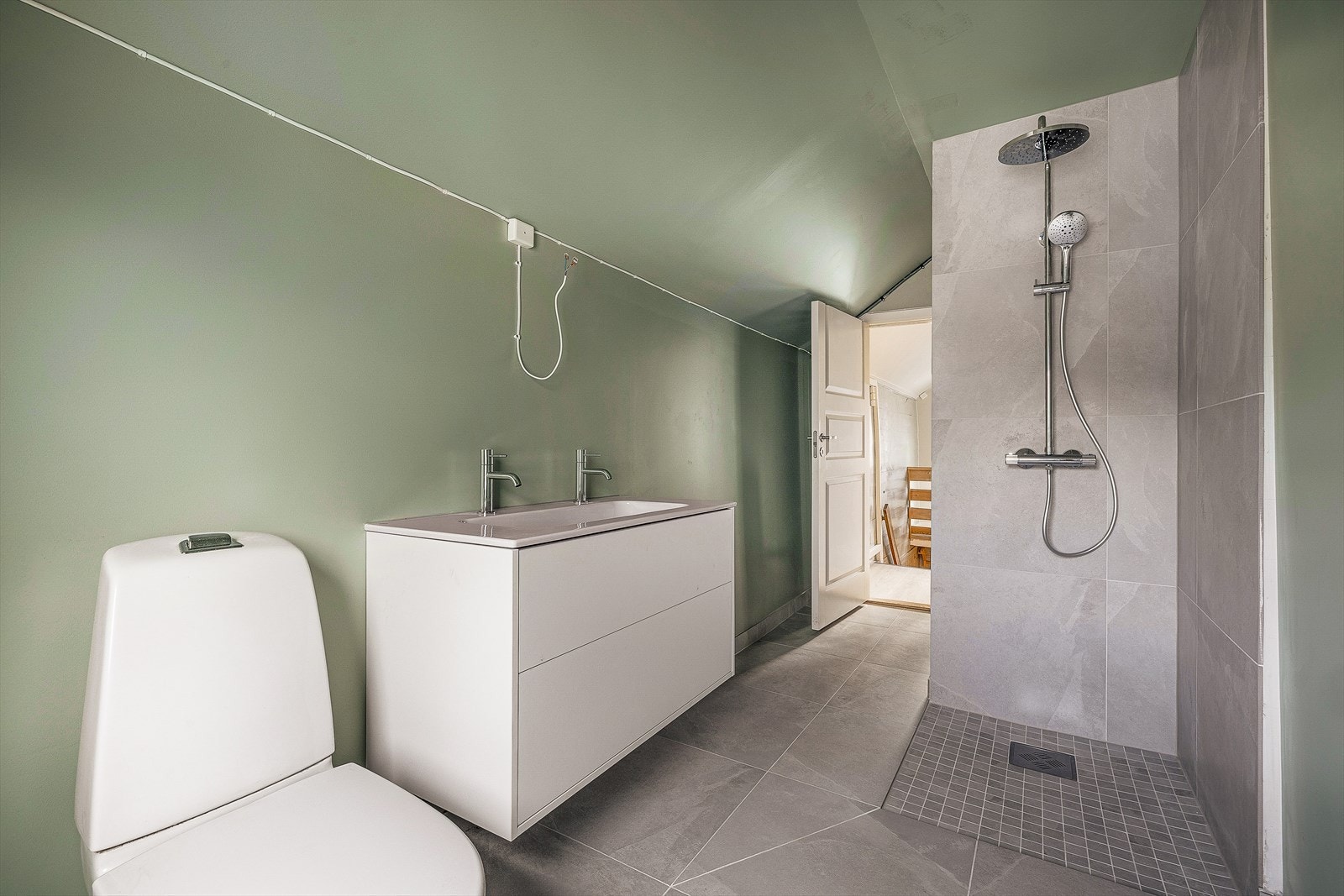 Boligens hovedbaderom er også pusset opp i 2026. Som bildet viser er mangler rommet speil og dusjdører, dette må ny eier besørge, men er ellers utført med moderne, tidsriktige løsninger. Galleribilde