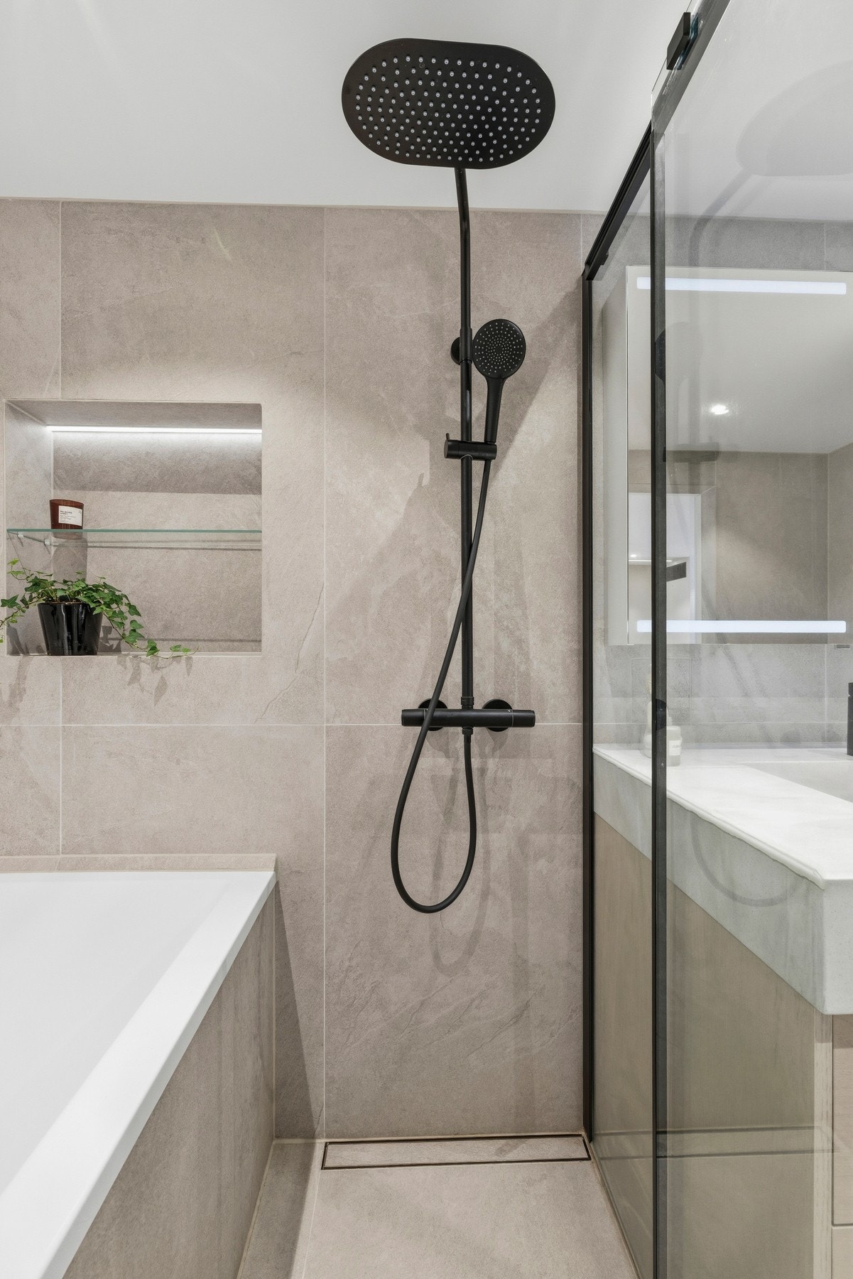 Badet er utstyrt med både dusj og badekar. De store 60x120 flisene gir kvalitetsfølelse! Galleribilde