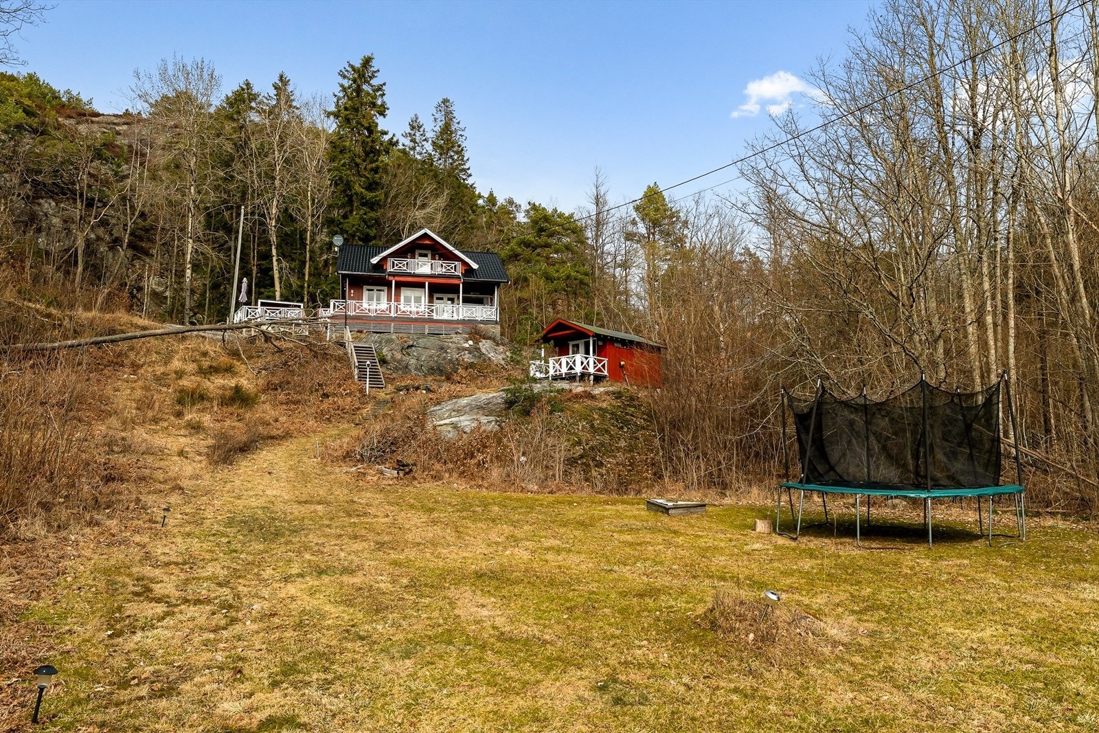 Området med gresslette nedenfor hytte ligger på utsiden av tomten, men har vært benyttet av hytteeier til trampoline, lek og ballspill. Galleribilde