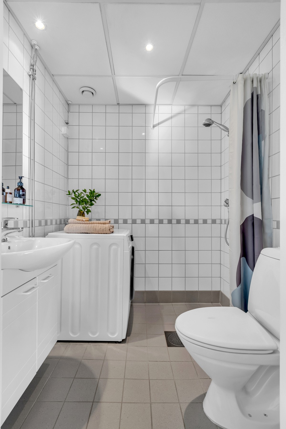 Badet er innredet med dusjnisje, veggmontert servantskap, toalett og opplegg for vaskemaskin. Galleribilde