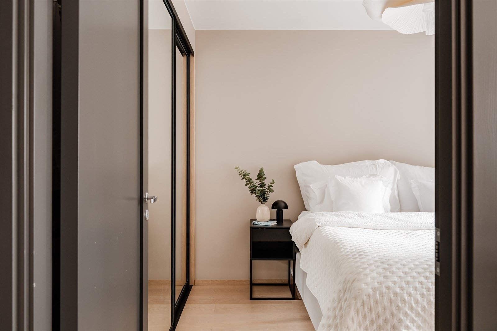 Her har du et romslig soverom med plassbygd garderobe i eik for organisert og effektiv oppbevaring. Galleribilde