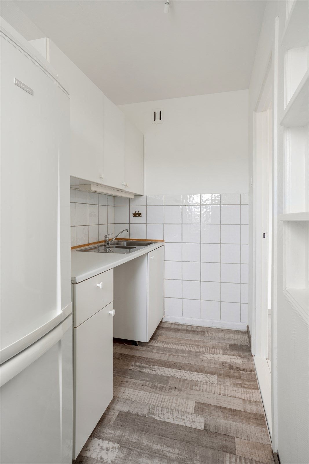 Kjøkkeninnredningen består av under-/overskap og slette fronter. Galleribilde