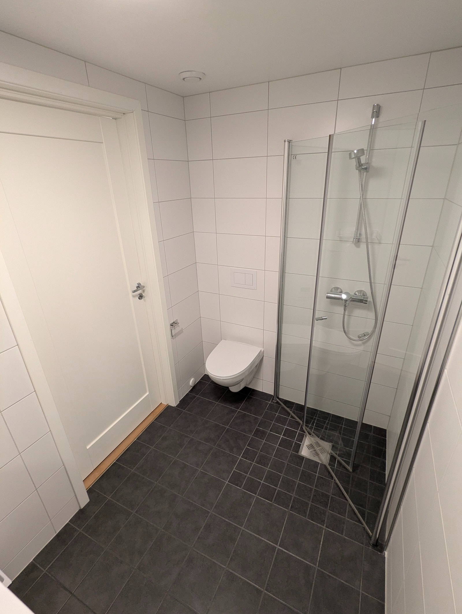 Dusjhjørne m/ innfellbare glassdører og vegghengt toalett Galleribilde