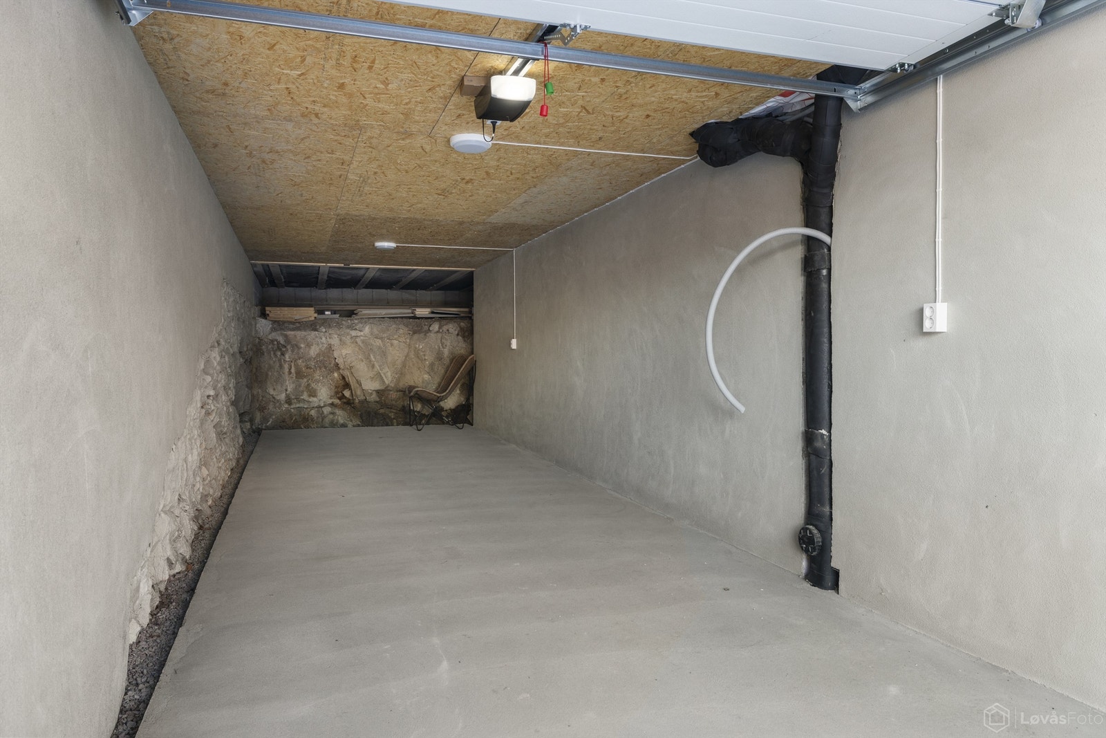 Integrert i boligens underetasje ligger garasjen med plass til 2 biler etter hverandre. Det er lagt trekkerør til garasjen og til legen utvendig parkeringsplass for evt. etablering av elbillader. Ny elektrisk garasjeport i 2025 Galleribilde