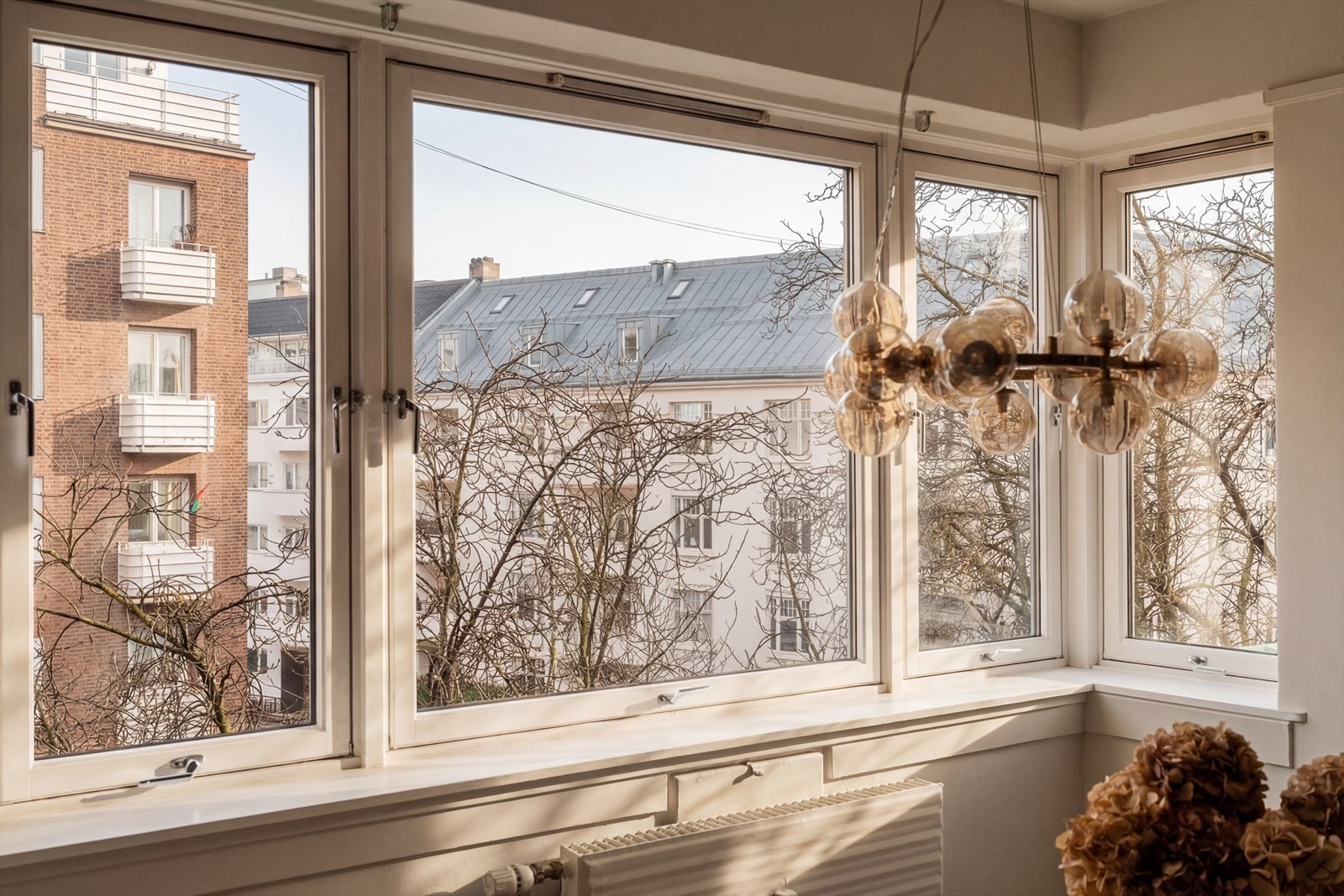 Store vindusflater med isolerglass fra 1989 som slipper inn rikelig med naturlig dagslys. Bildet er redigert med AI for å illustrere lysinnslippene på solskinnsdager. Galleribilde