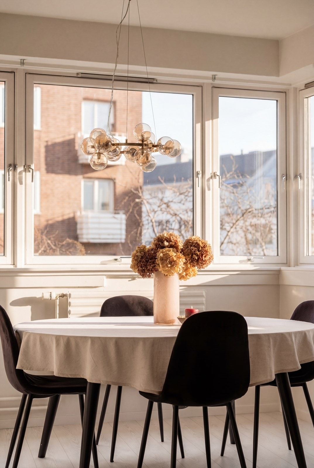 Ved kjøkkenet har du god plass til en hyggelig sosial sone ved lyse vinduer. Bildet er AI redigert for å illustrere lysforholdene i leiligheten på solskinnsdager. Galleribilde