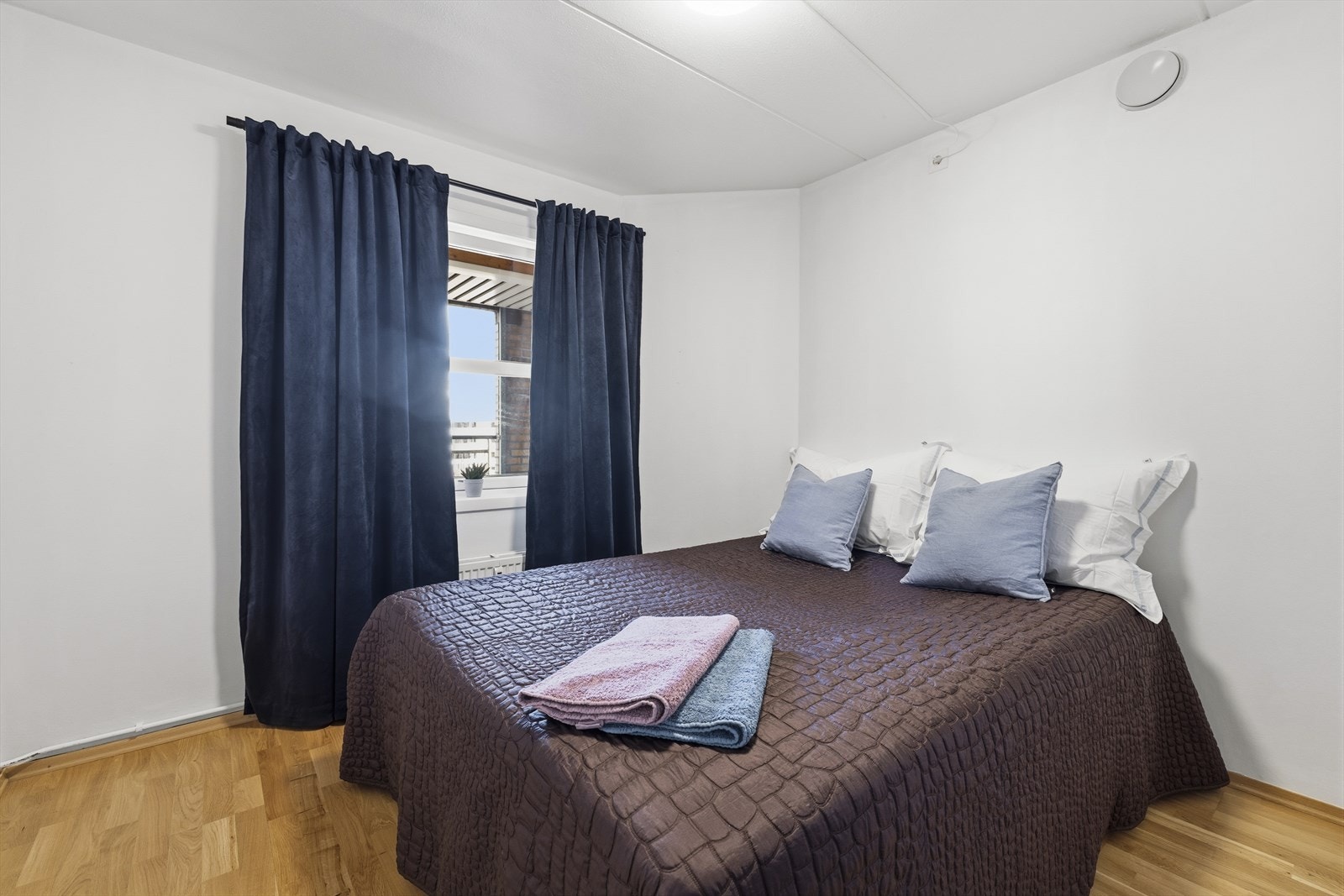 Romslig soverom med god plass til dobbeltseng, nattbord på hver side og øvrig møblement. Galleribilde