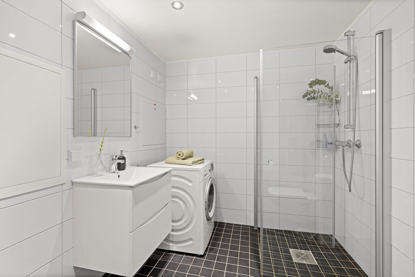 Badet består av flislagt gulv med gulvvarme og flislagte vegger. Galleribilde
