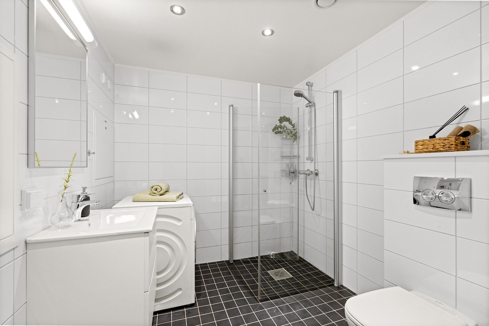 Dusj med innfellbare glassdører, speil med overlys og opplegg for vaskemaskin. Galleribilde