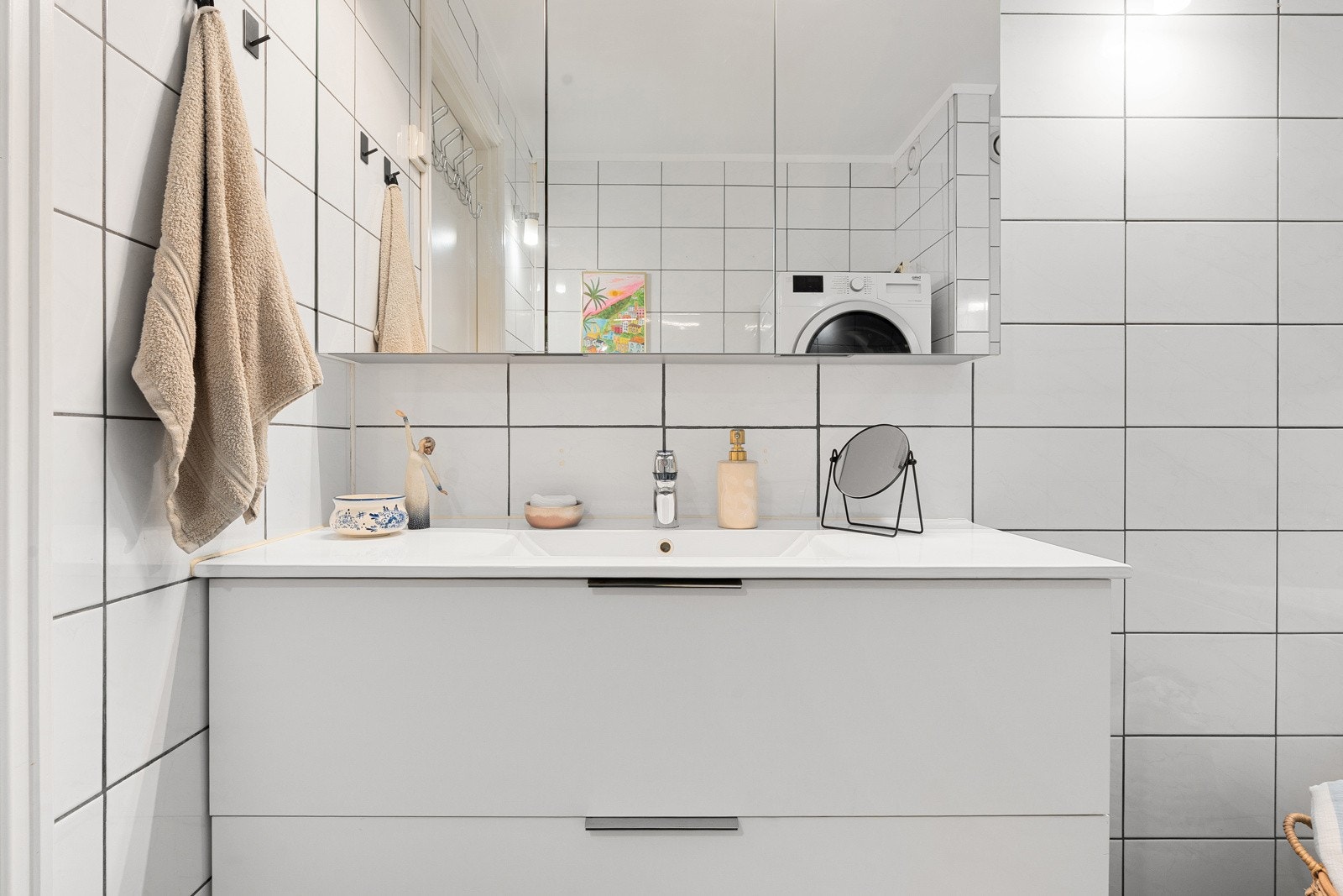 Baderomsinnredningen har rikelig med oppbevaringsplass i skap og skuffer.