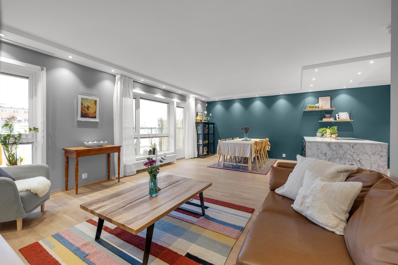 Stue og kjøkken er i åpen løsning, med moderne og tidsriktige farger. Galleribilde