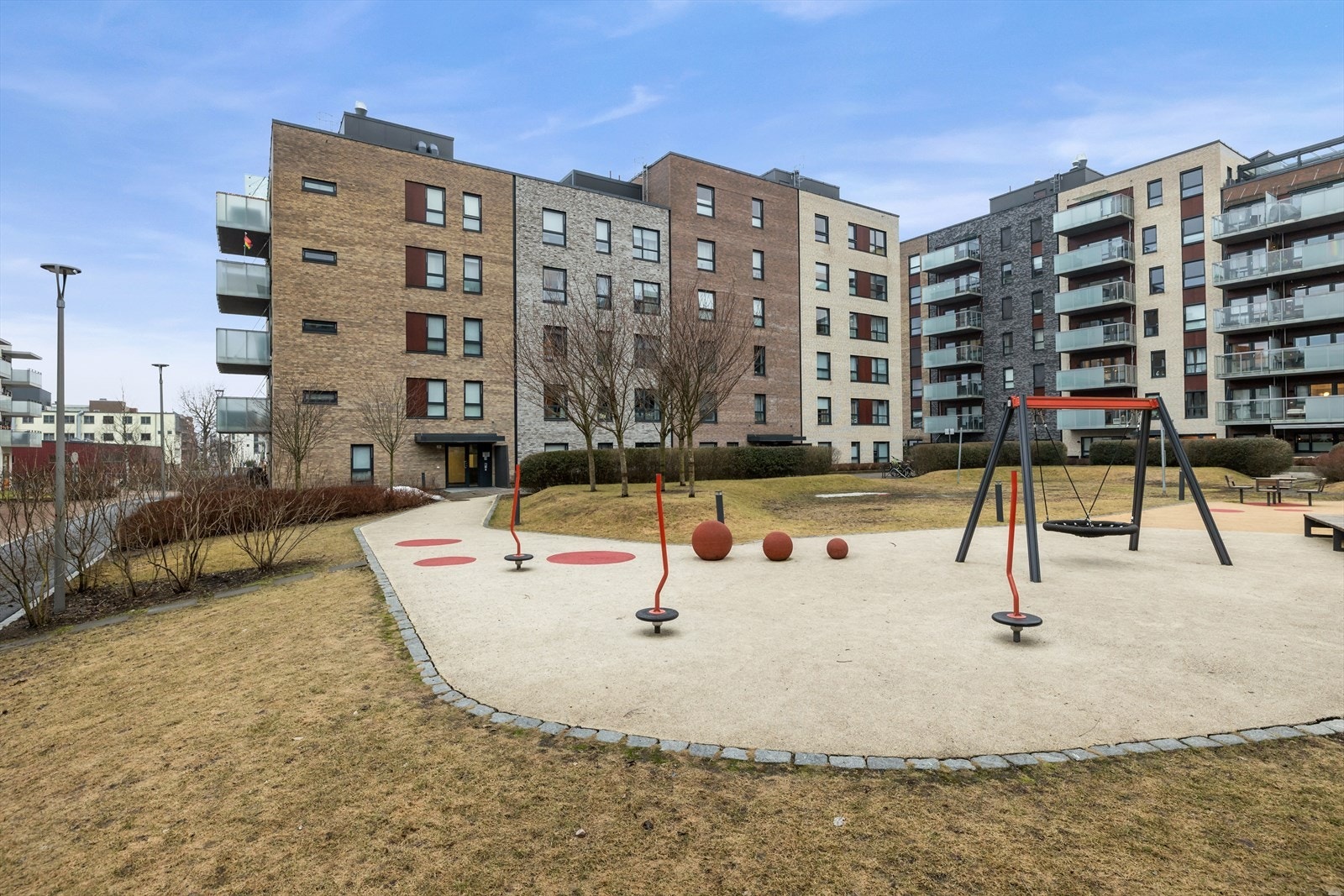 Tomten er pent opparbeidet med grøntarealer, lekeplass, sittegrupper og gangstier mellom blokker. Trærne blomstrer nydelig hver vår. Galleribilde