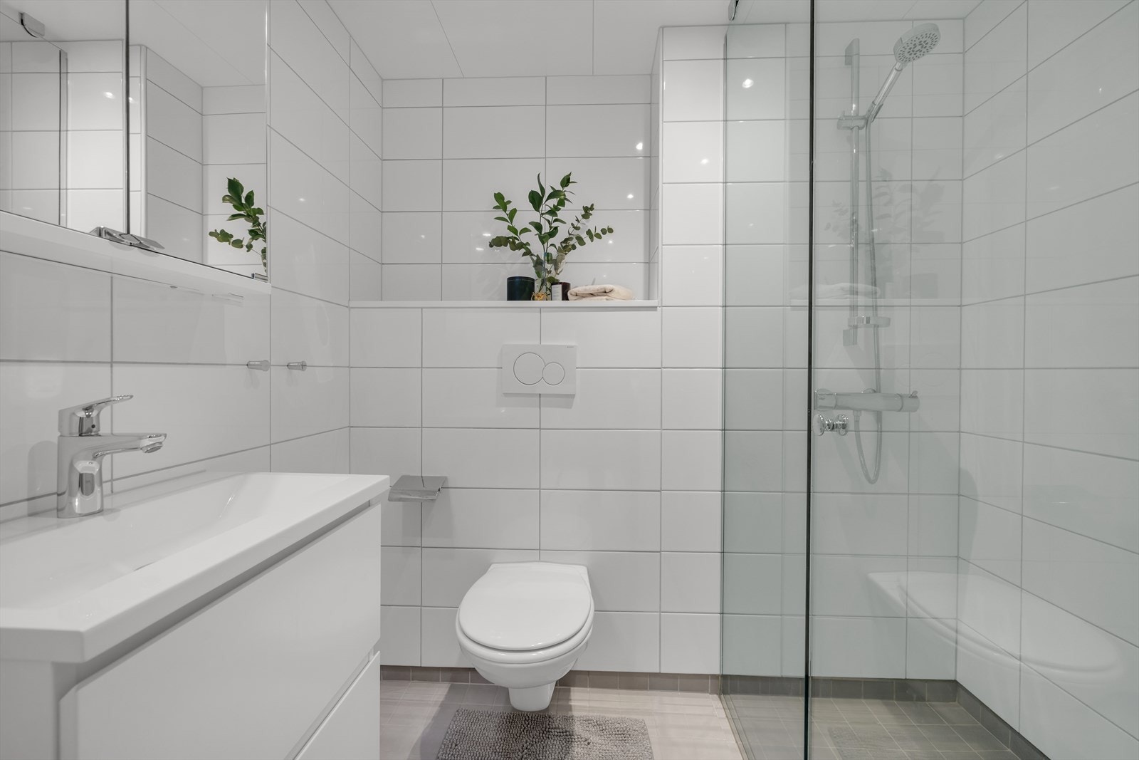 Baderommet i tilknytning til soverommet av type badekabin, og fremstår med fliser på vegger og gulv. Galleribilde