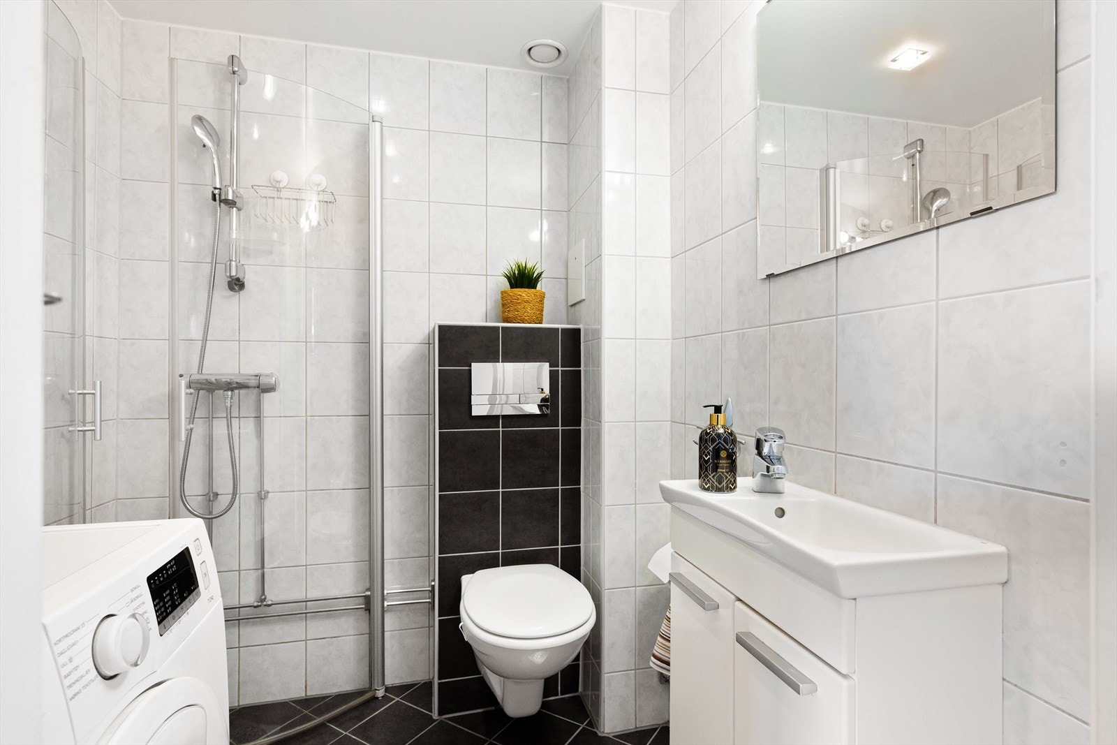 Pent, flislagt baderom med gulvvarme og opplegg for vaskemaskin. Galleribilde