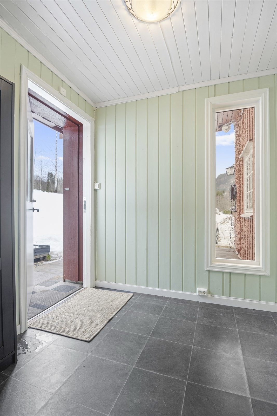 Lys og romslig entré med fliser og varmekabler, med god plass til oppbevaring av sko og ytterklær. Galleribilde