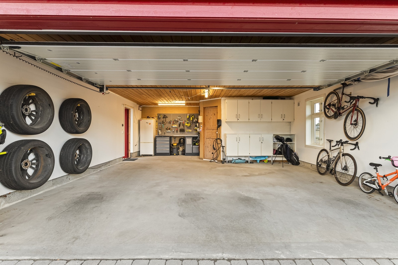 Dobbelgarasjen fra 2009 har elektrisk leddport og installert lader for elbil. Galleribilde
