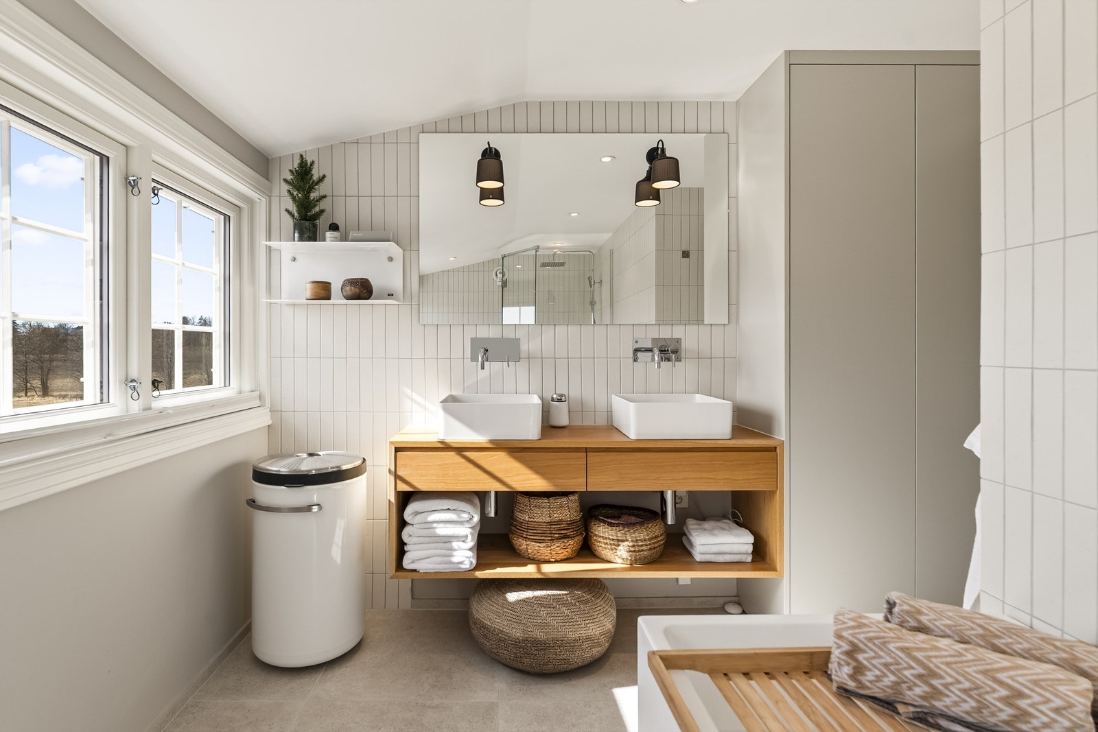 Flislagte overflater og innfelte downlights gir et rent og moderne uttrykk. Vannrør er av typen rør-i-rør. Galleribilde
