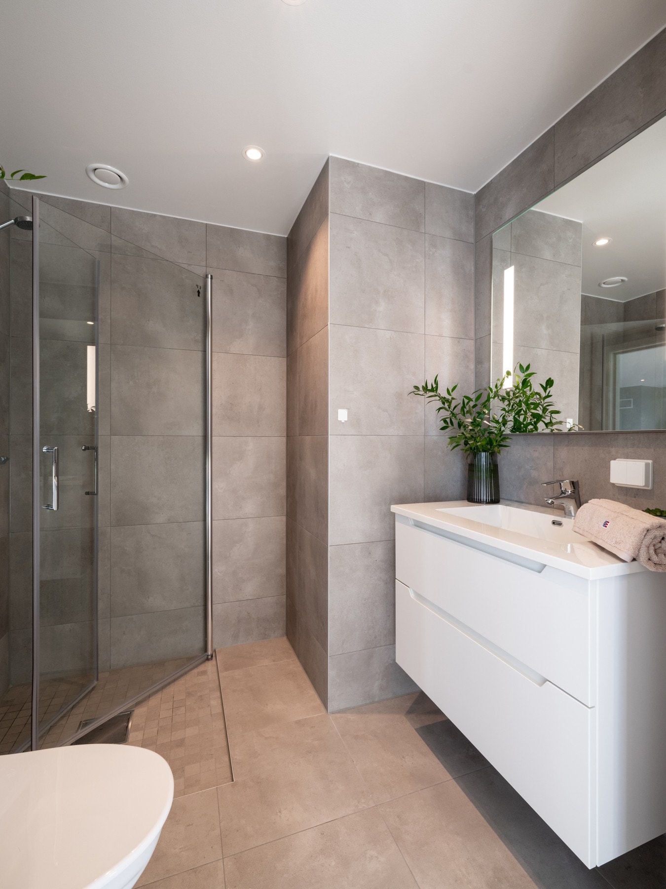 Badet er lekkert flislagt med varme i gulv og downlights i himling. Galleribilde