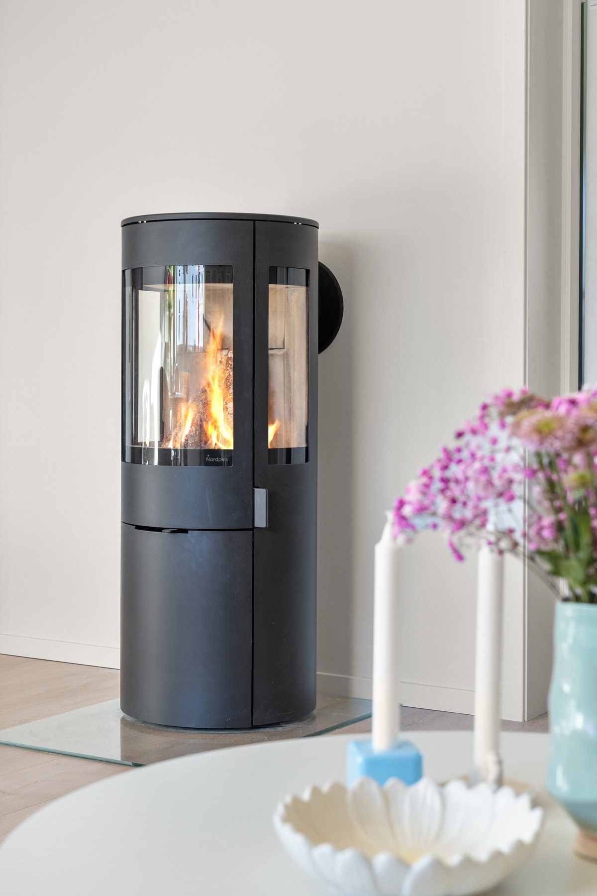 Det er peis i stuen med glass på flere sider, slik at man ser flammene fra både sofa og spiseplassen. Galleribilde