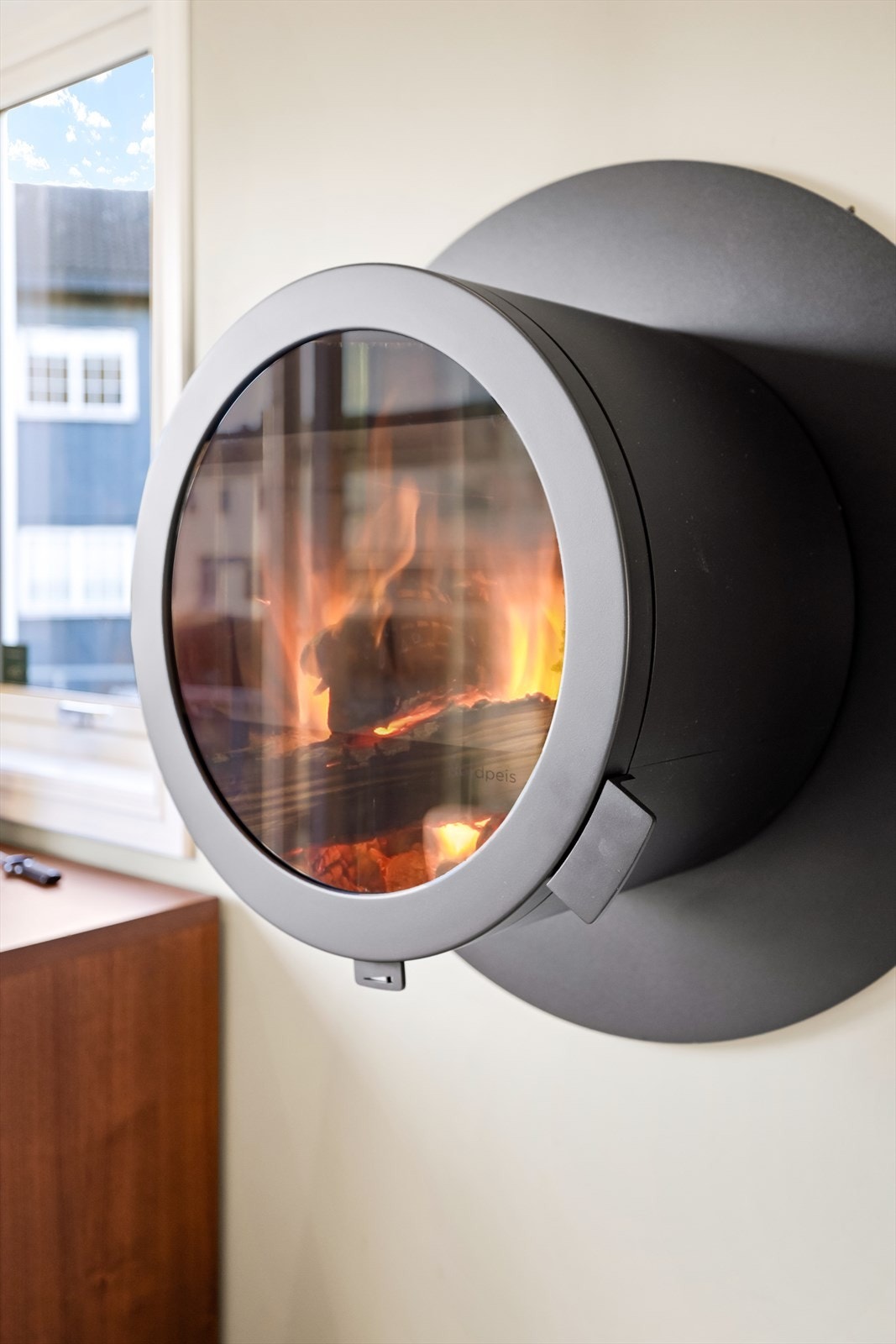 Vegghengt peisovn med et moderne, rundt design fra Nordpeis, installert i 2023. Galleribilde