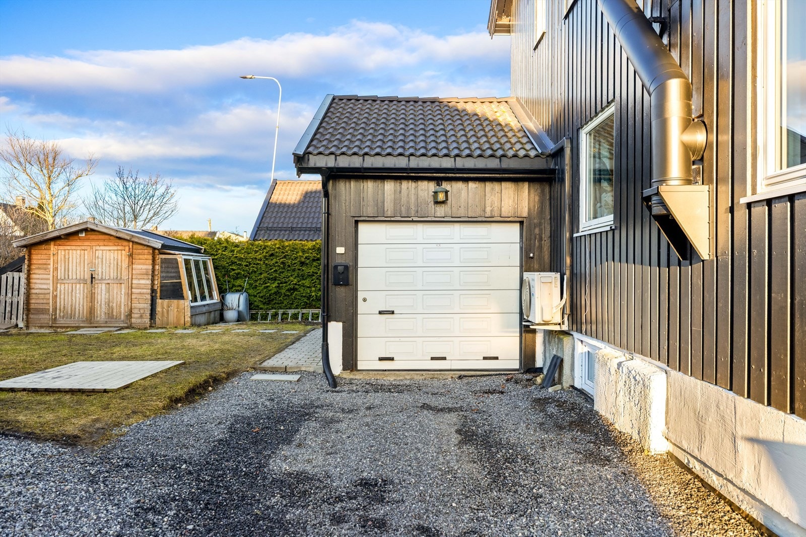 Garasjen har leddport og elbil-lader. Galleribilde