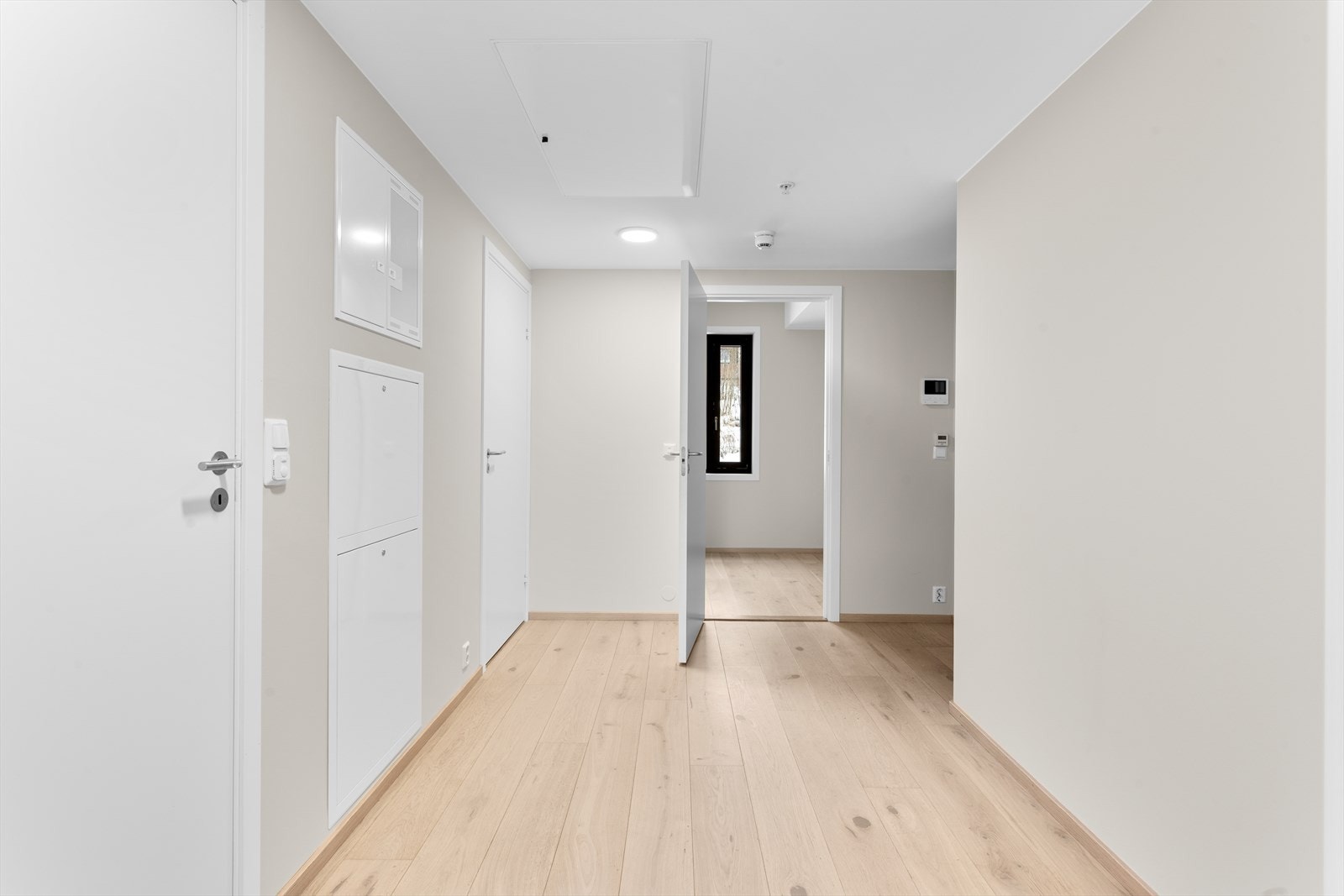 Innbydende entré med 1-stavs eikeparkett på gulv og malte, slette overflater. Her er det god plass til garderobeløsning. Galleribilde
