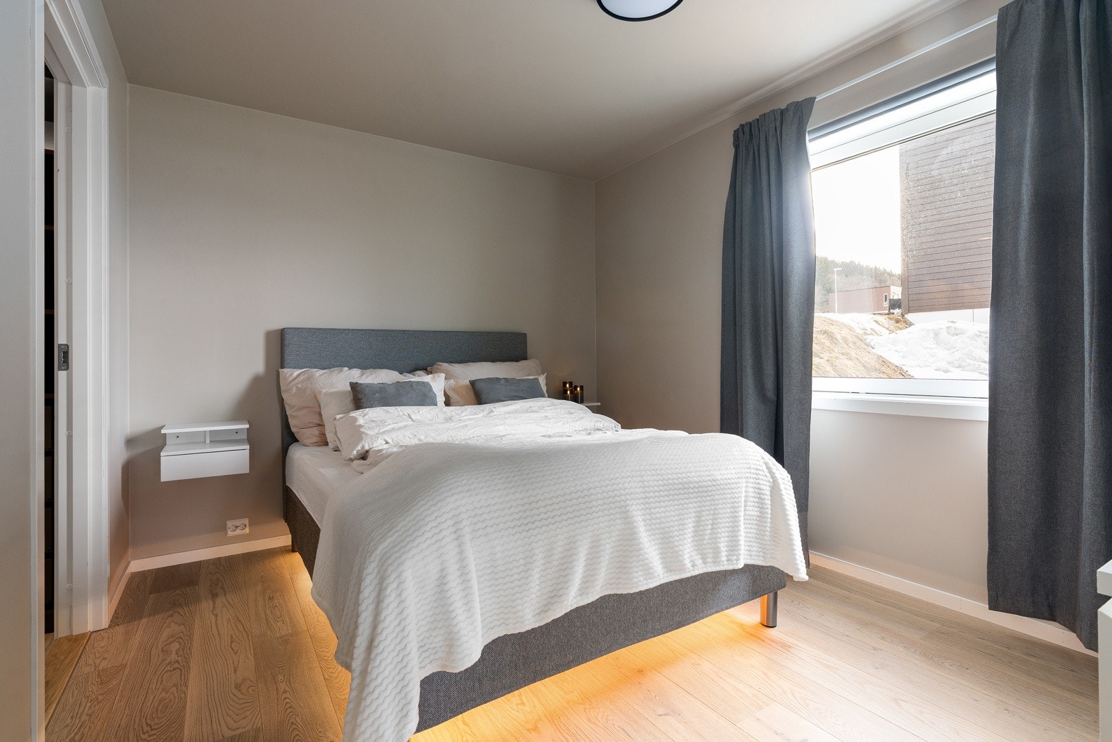 Romslig hovedsoverom med praktisk walk-in garderobe og god plass til dobbeltseng.