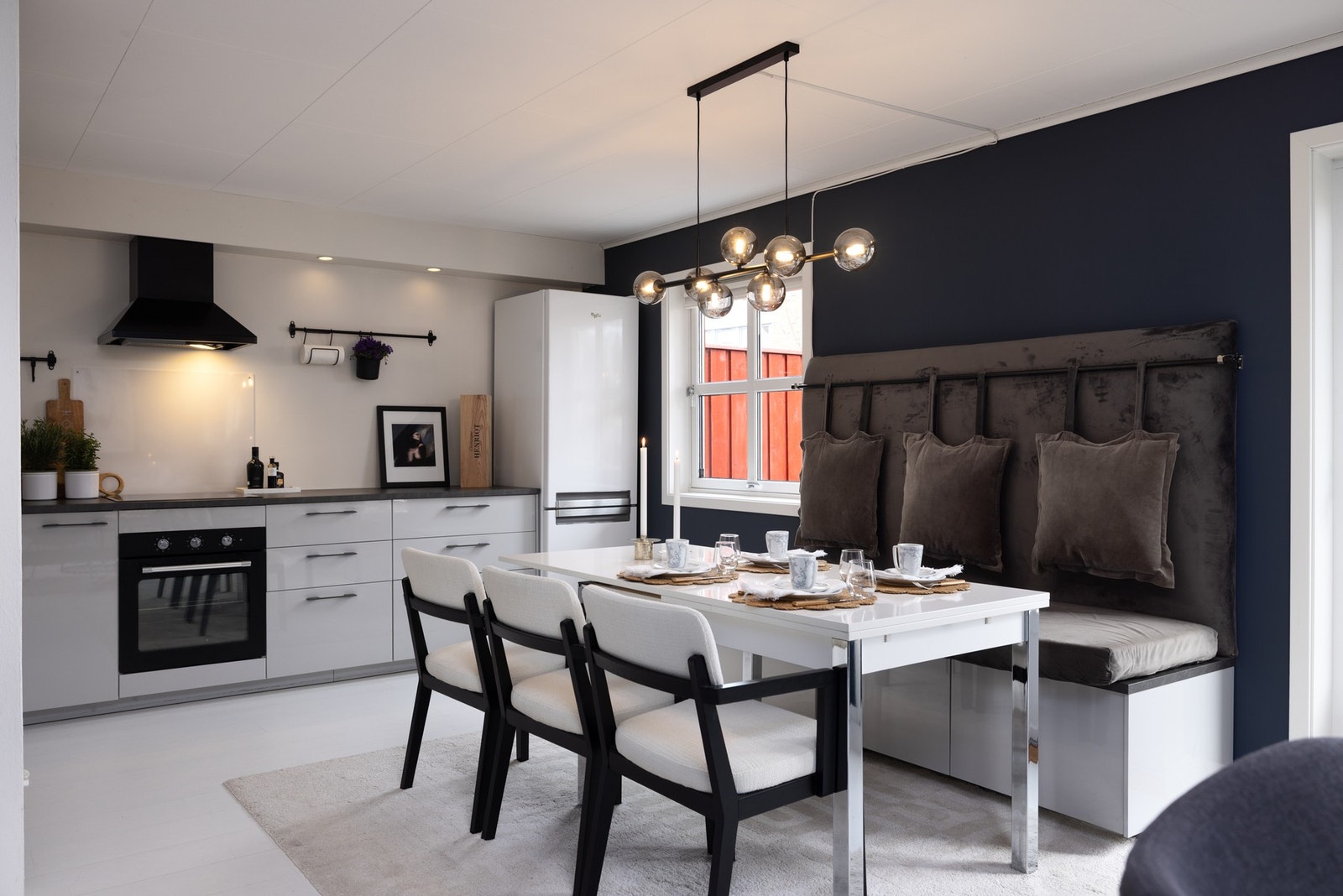 Moderne kjøkken i åpen løsning med integrert spiseplass og gode arbeidsflater. Galleribilde