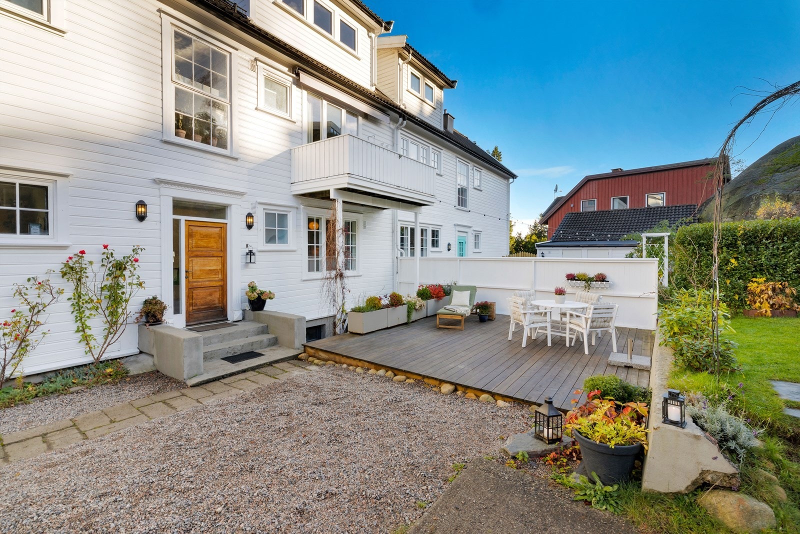 Pent opparbeidet felles bakgård med platting, steinheller, ulike sittegrupper og frodig hage vår, sommer og høst. Galleribilde