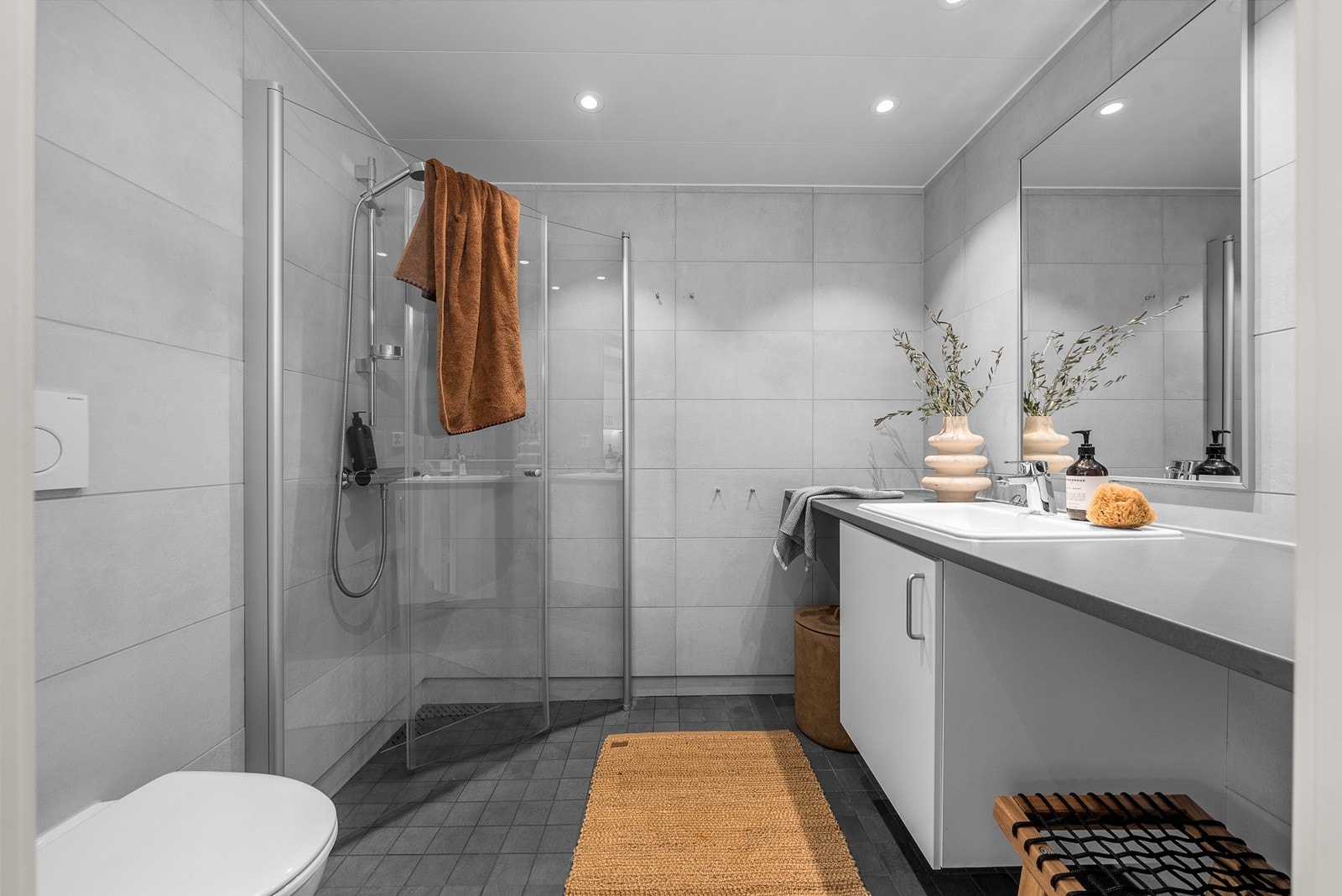 Badet holder en moderne standard med flislagte overflater og varmekabler i gulv Galleribilde
