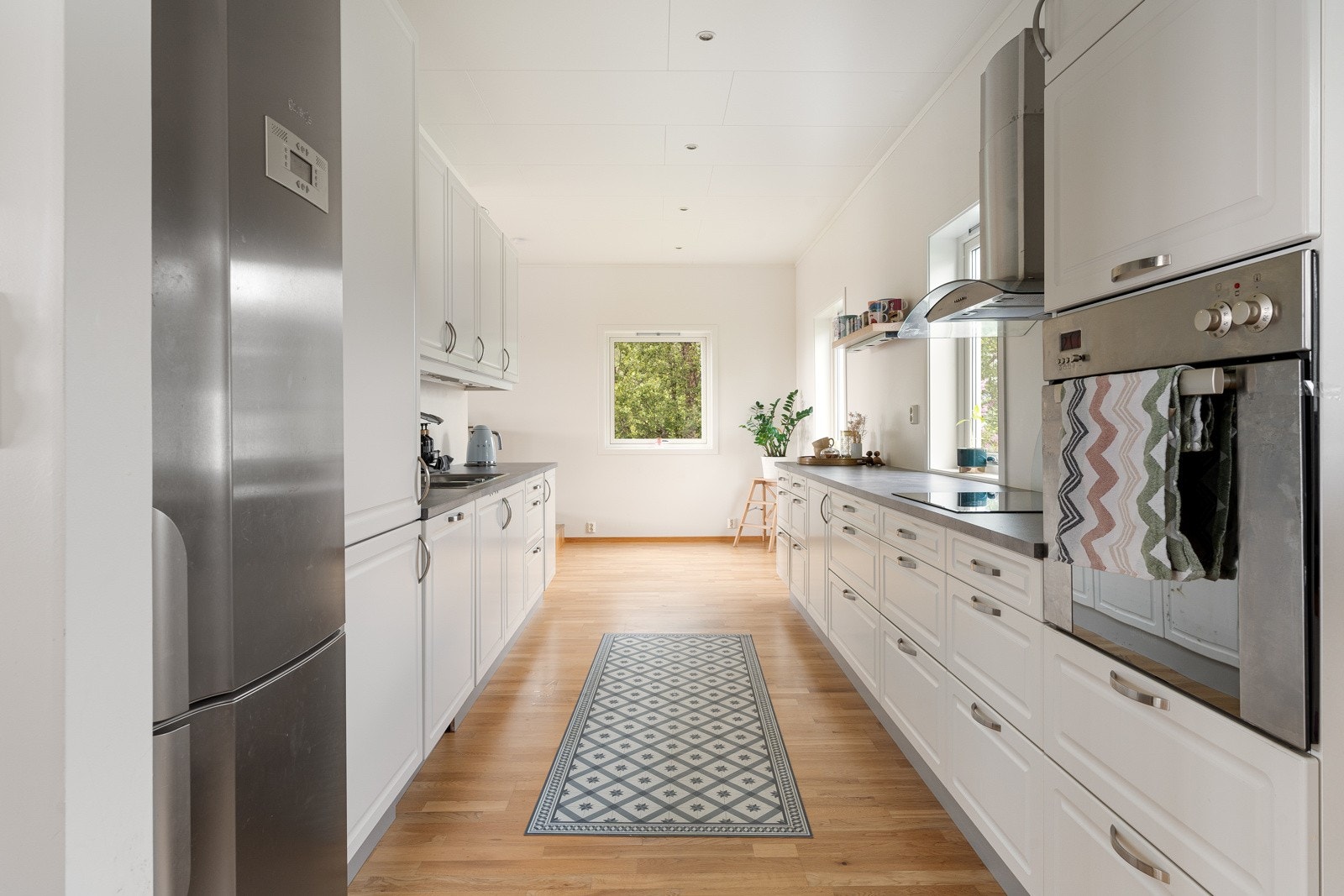 Fra trapp kommer du opp til kjøkkenet som ligger i delvis åpen løsning med oppholdsrom.