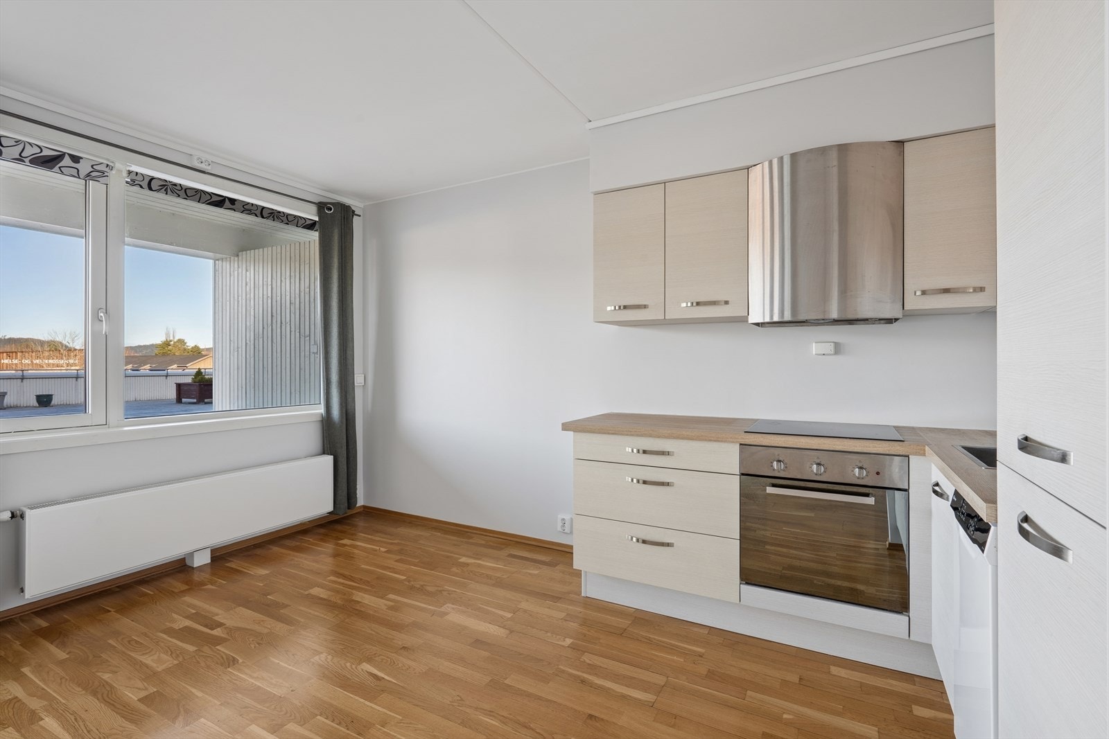 Kjøkken med lyse, glatte fronter og laminat benkeplate. Galleribilde