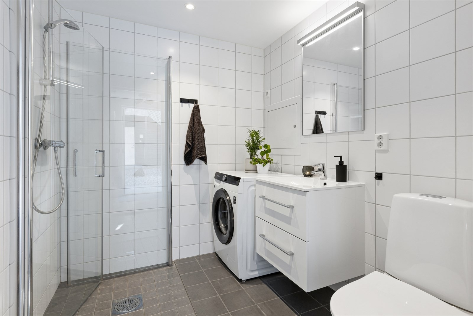 Moderne og lyst bad med flisbelagt gulv og vegger. Galleribilde