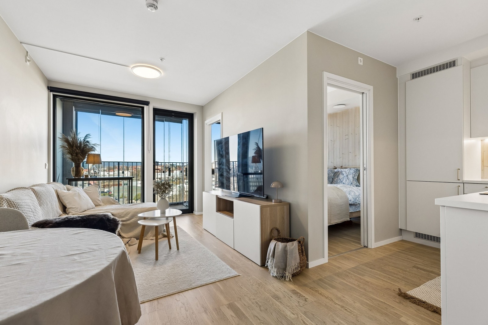 Åpen og innbydende stue med god plass til både sofa og spisebord Galleribilde
