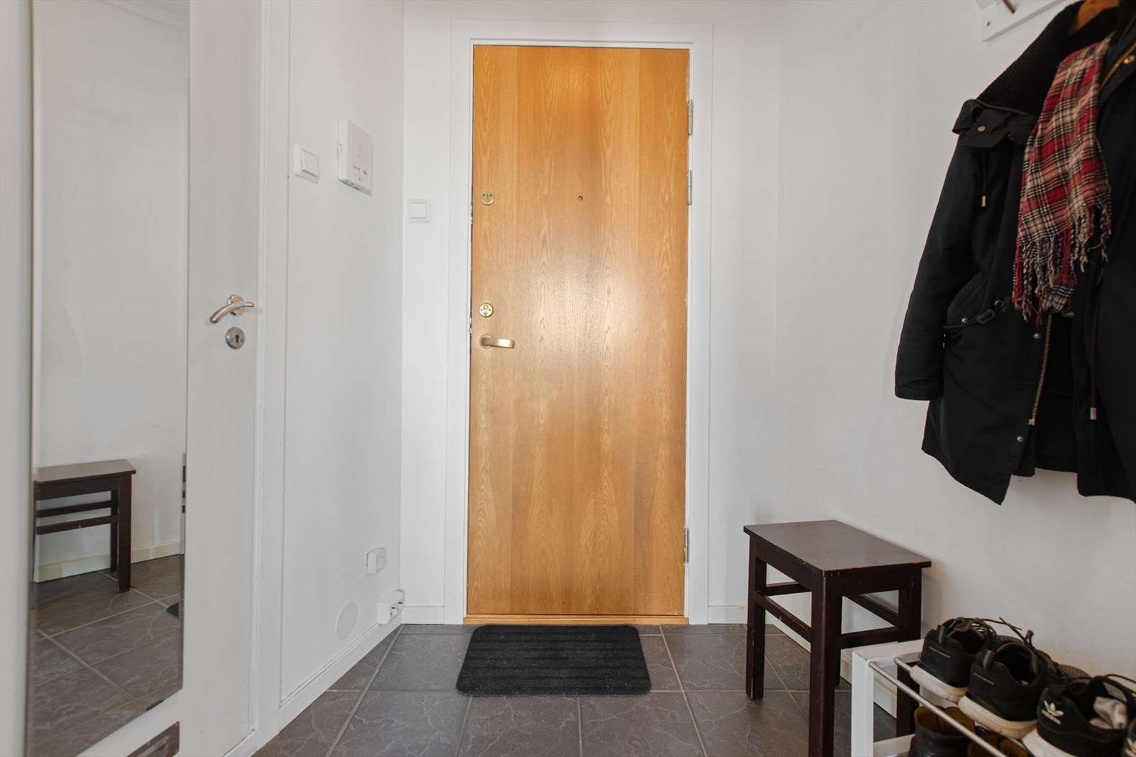 Entré med flislagt gulv, plass til knaggrekke og direkte adkomst inn til badet. Galleribilde